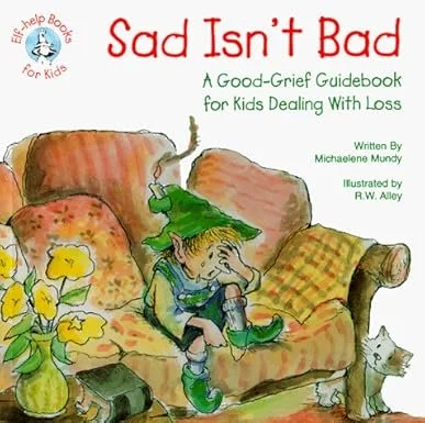 Cover of a children's book titled "Sad Isn't Bad: A Good-Grief Guidebook for Kids Dealing with Loss". The illustration shows a sad young boy sitting on a yellow and green checkered couch, with a green hat, a green shirt, and blue pants. He appears to