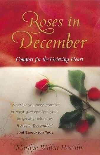 Book cover titled 'Roses in December: Comfort for the Grieving Heart' with a red rose and green leaves on a white and red background.