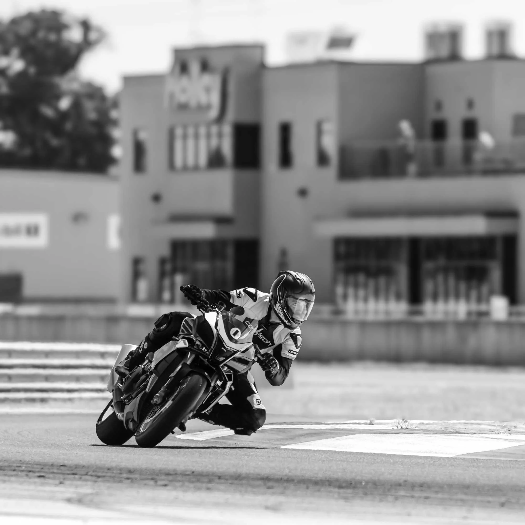 A man leaned over on a motorcycle riding on a race track
