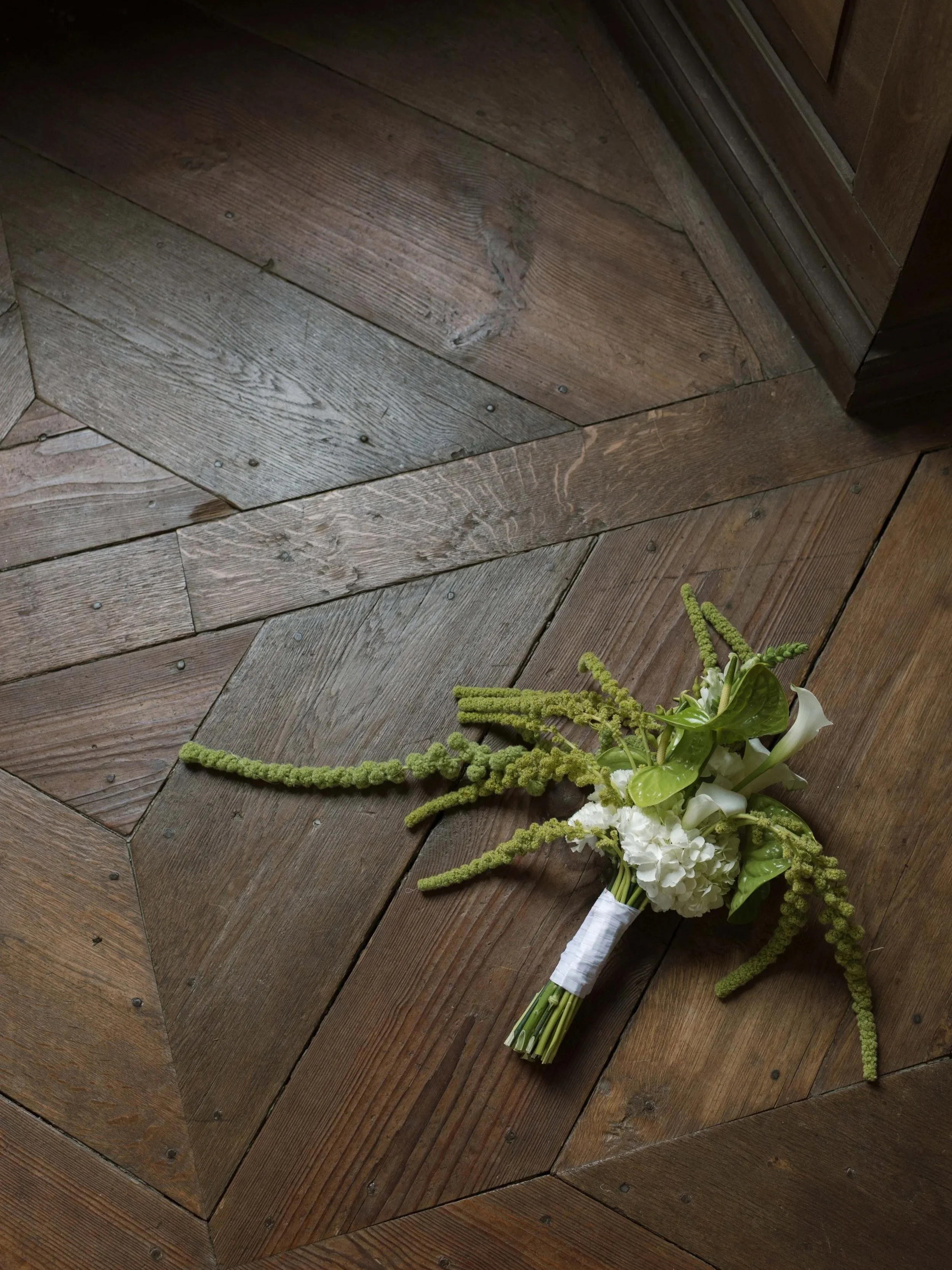 Ein Blumenstrauß liegt auf einem Holzfußboden.