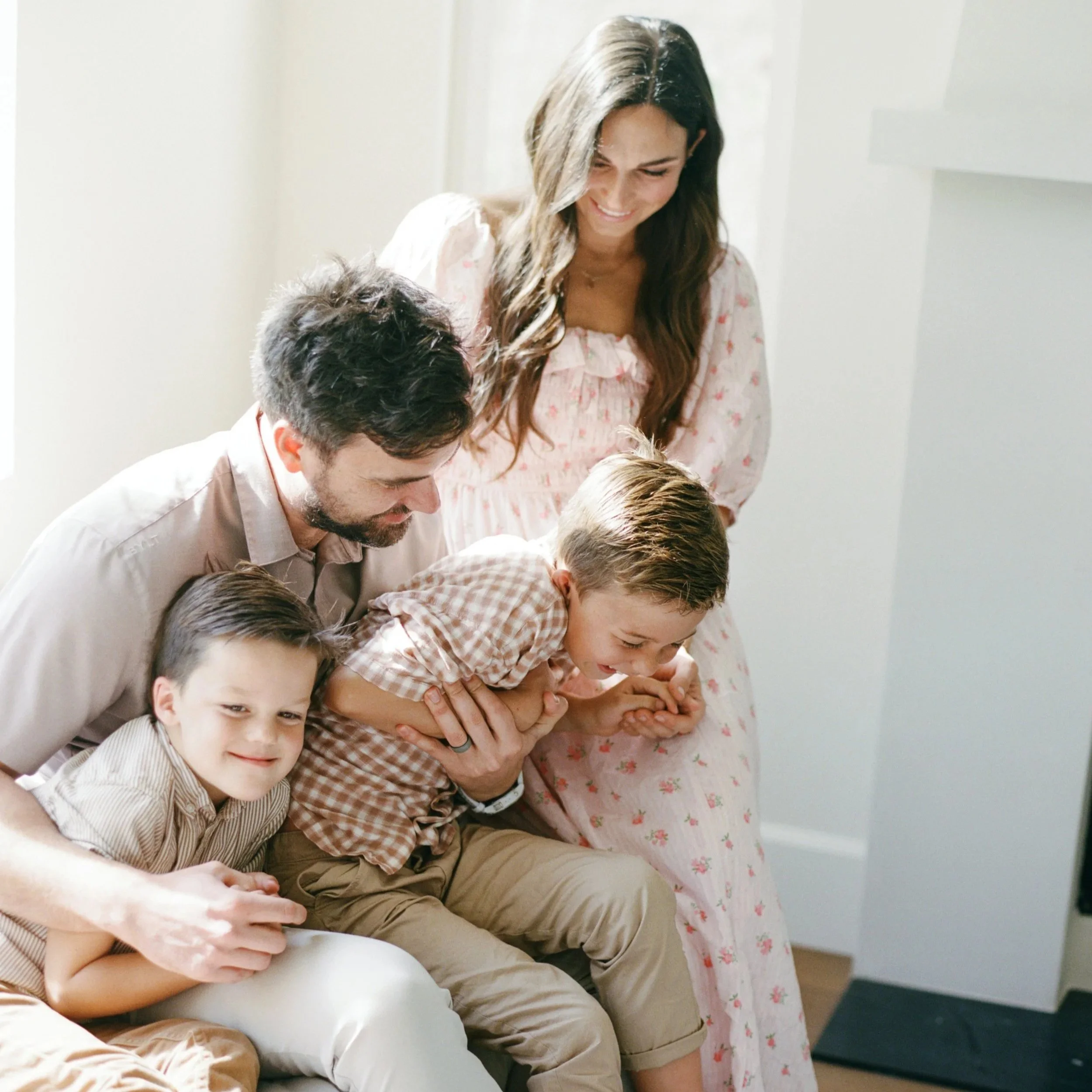 Lifestyle family photography moment: kids laughing on the couch during a relaxed home session in Orange County