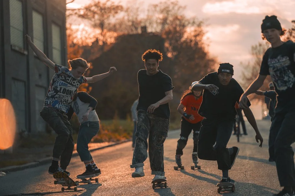 A group of young people roller skating on a street during sunset. Sk8 Liborius