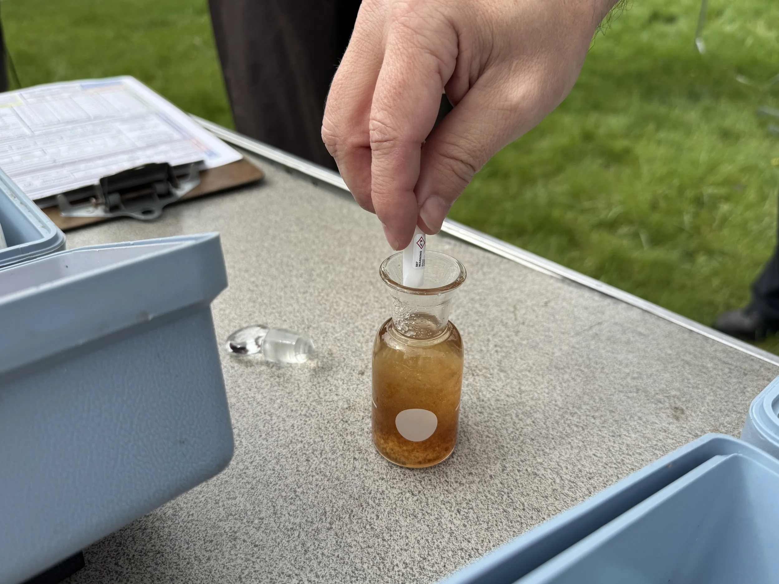 Instruction on use of the Hach dissolved oxygen kit; shown is the addition of reagent to dissolve the brownish orange flocculant precipitate created in Step 2, thus completing the fixing of oxygen in the collected stream sample.