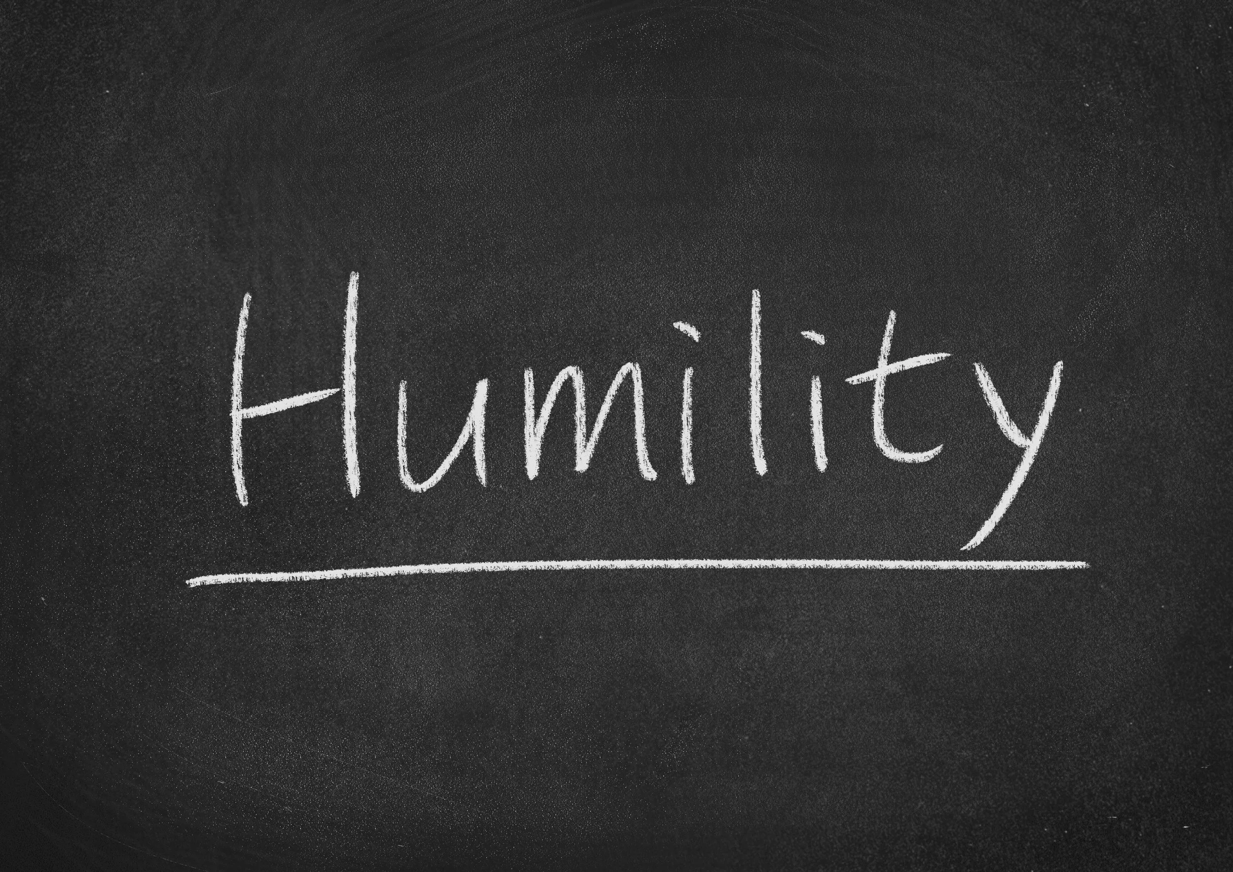 The word humility is written on a chalk board