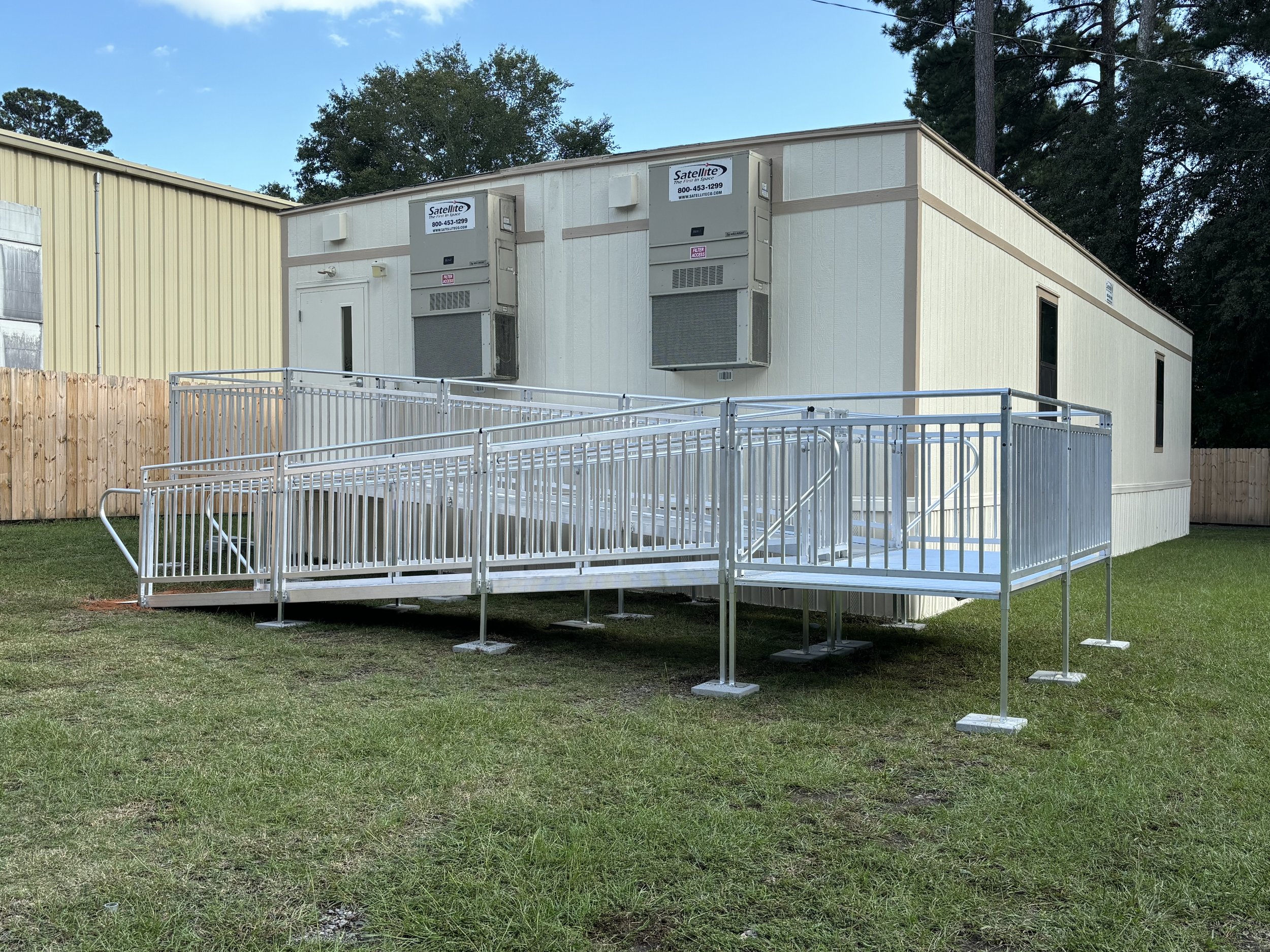 Commercial aluminum wheelchair ramp installed at a modular commercial building.