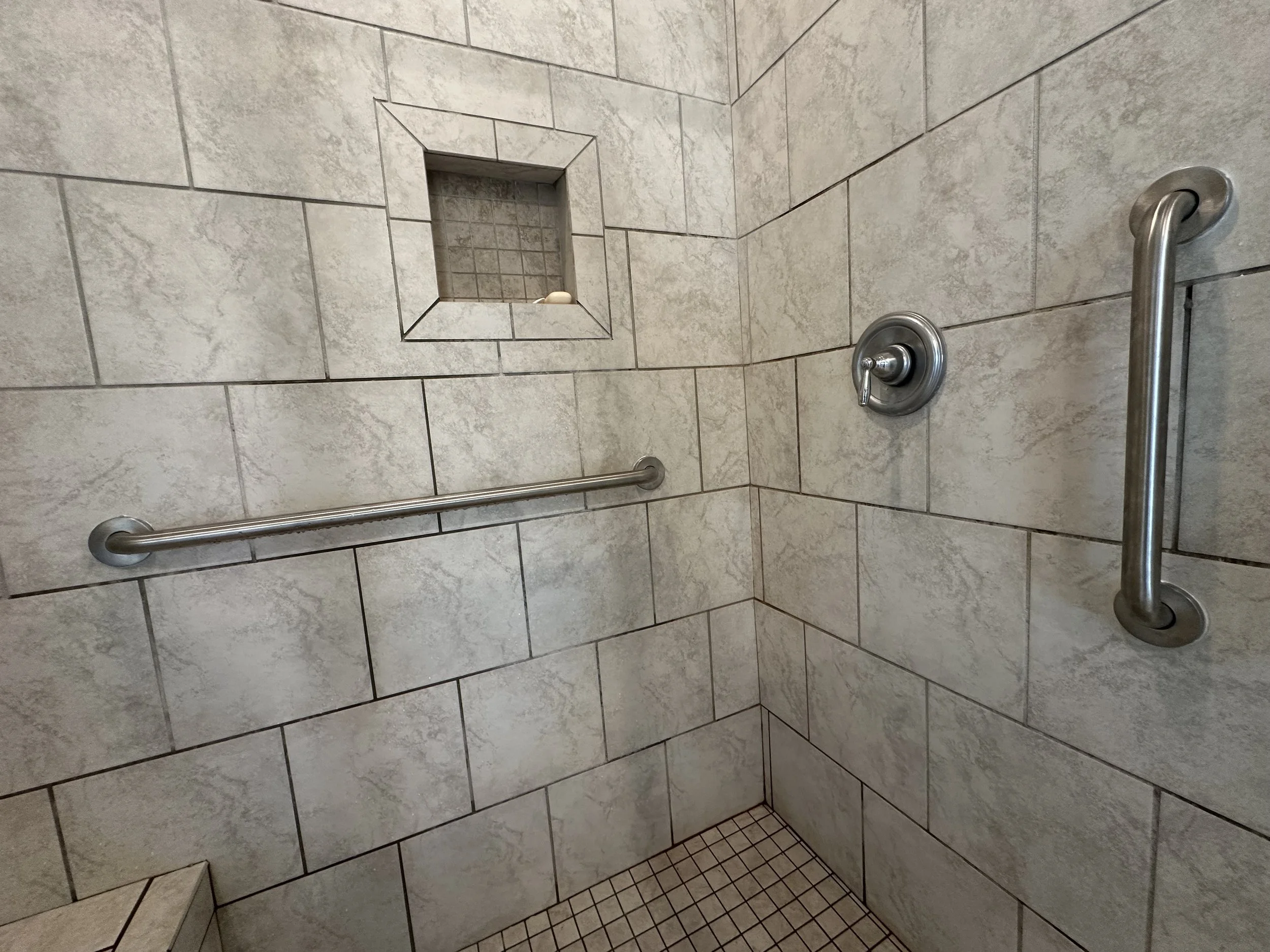 Vertical grab bar installed at a shower entry in a Gulf Shores home