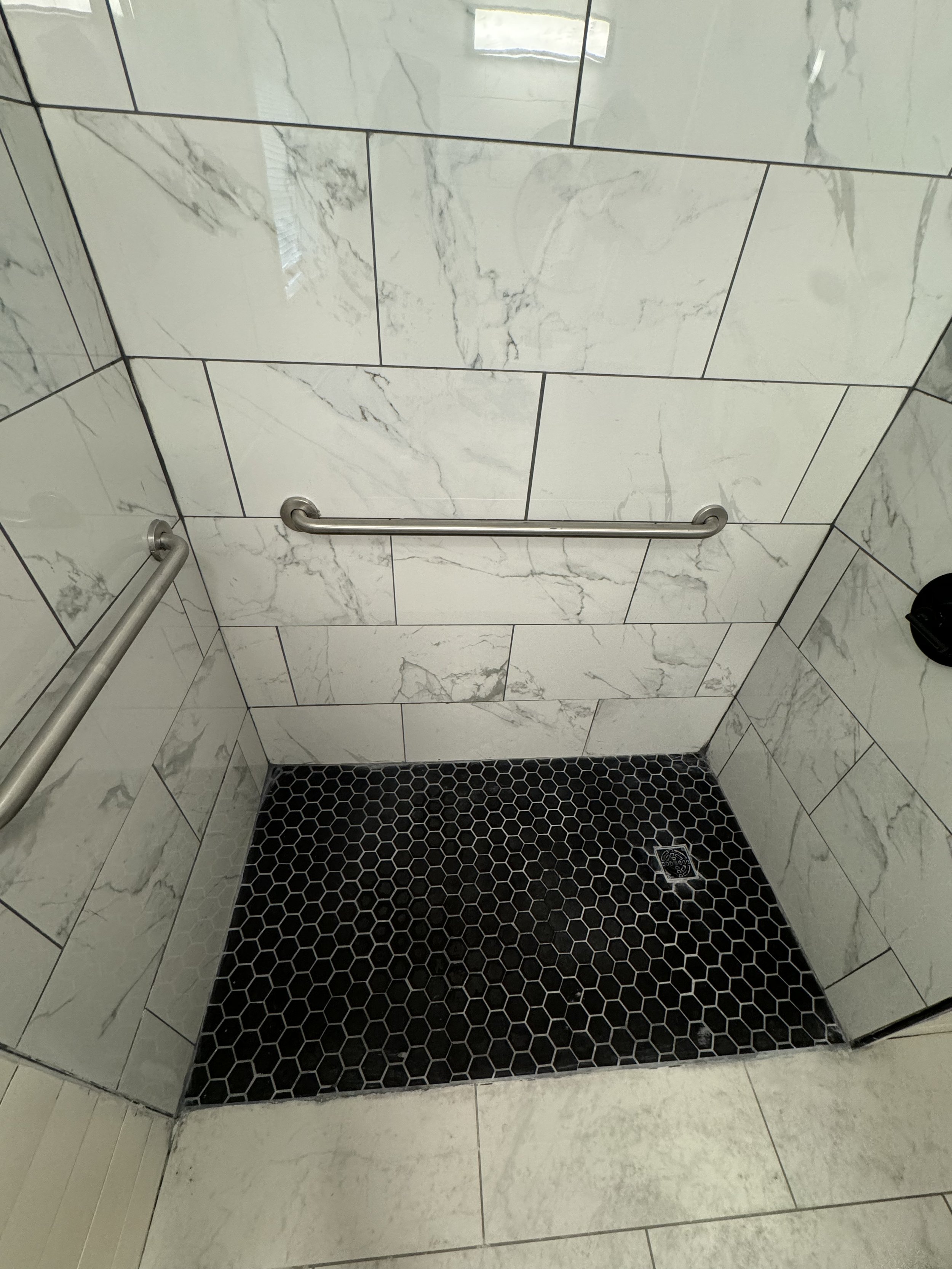 Accessible shower with grab bars on both walls for enhanced home safety and support.