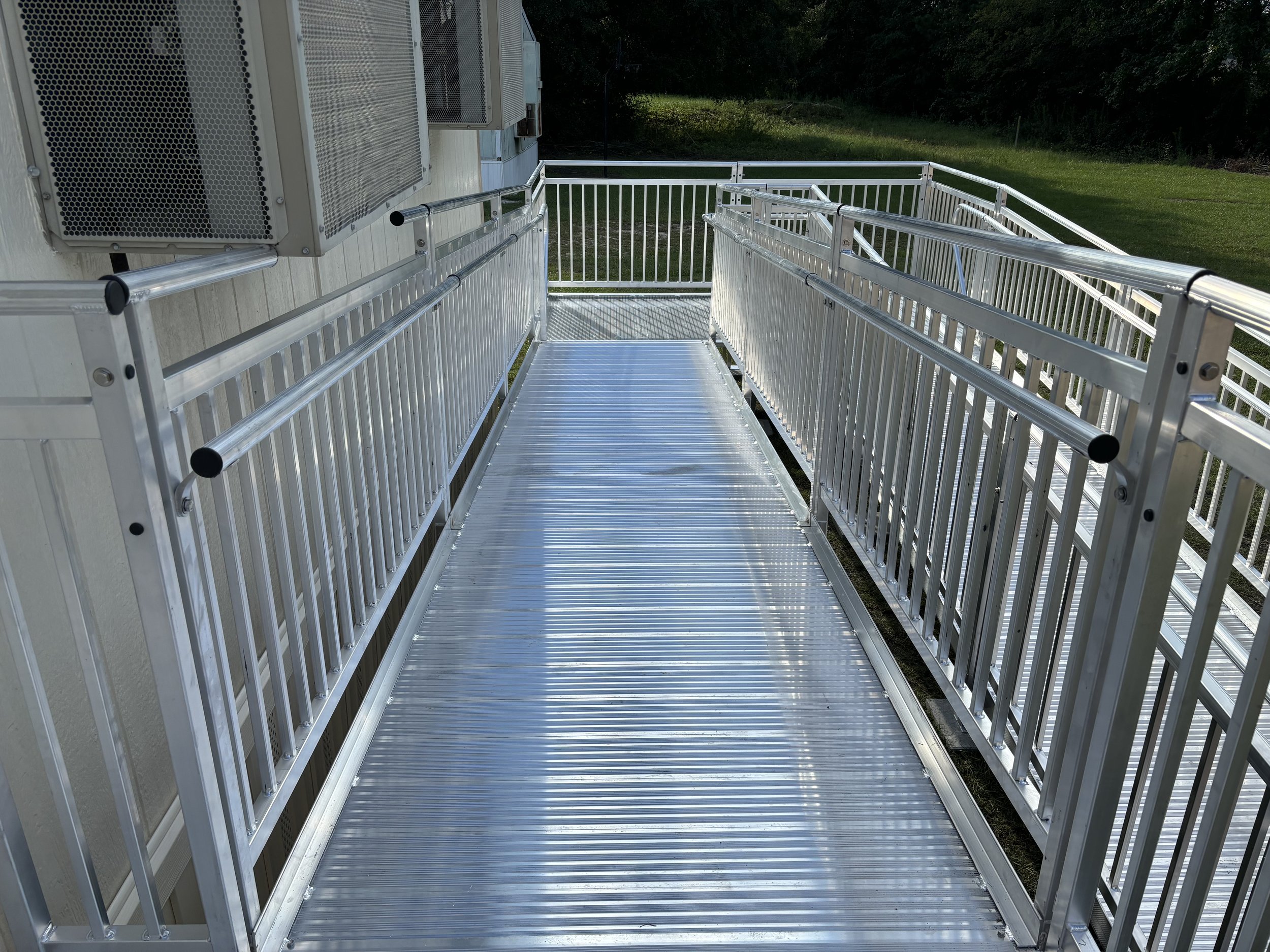 Close-up shot of descending aluminum ramp, providing durable, safe commercial access and easy mobility.