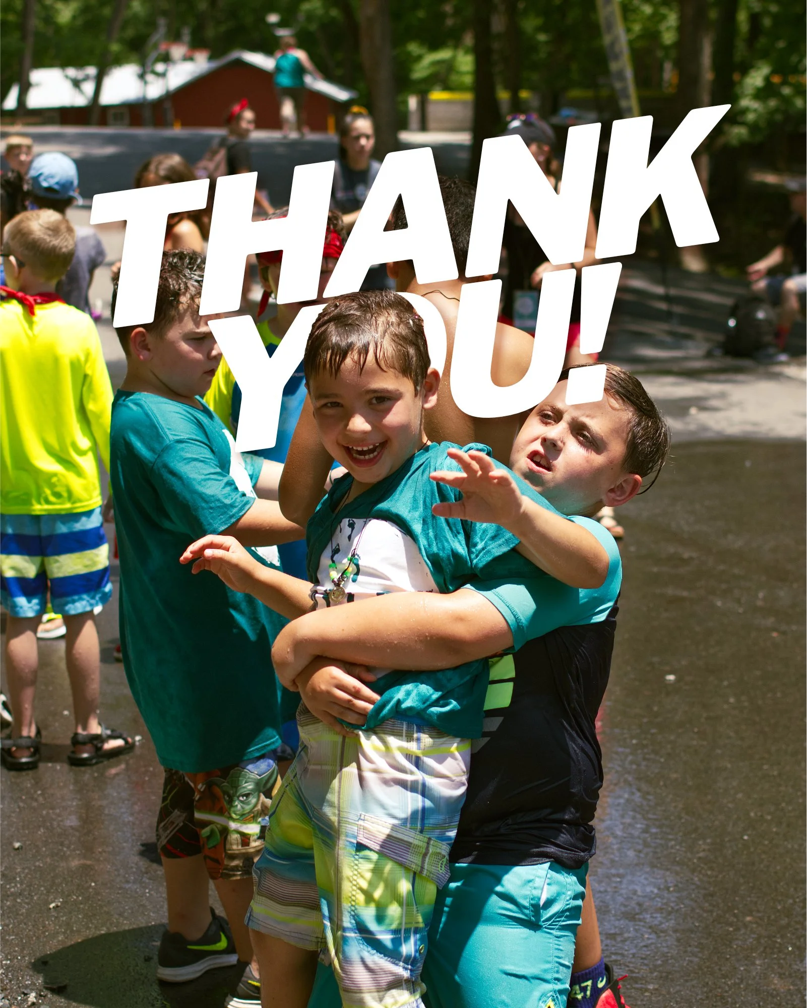 a boy hugs his friend who looks happily into the camera