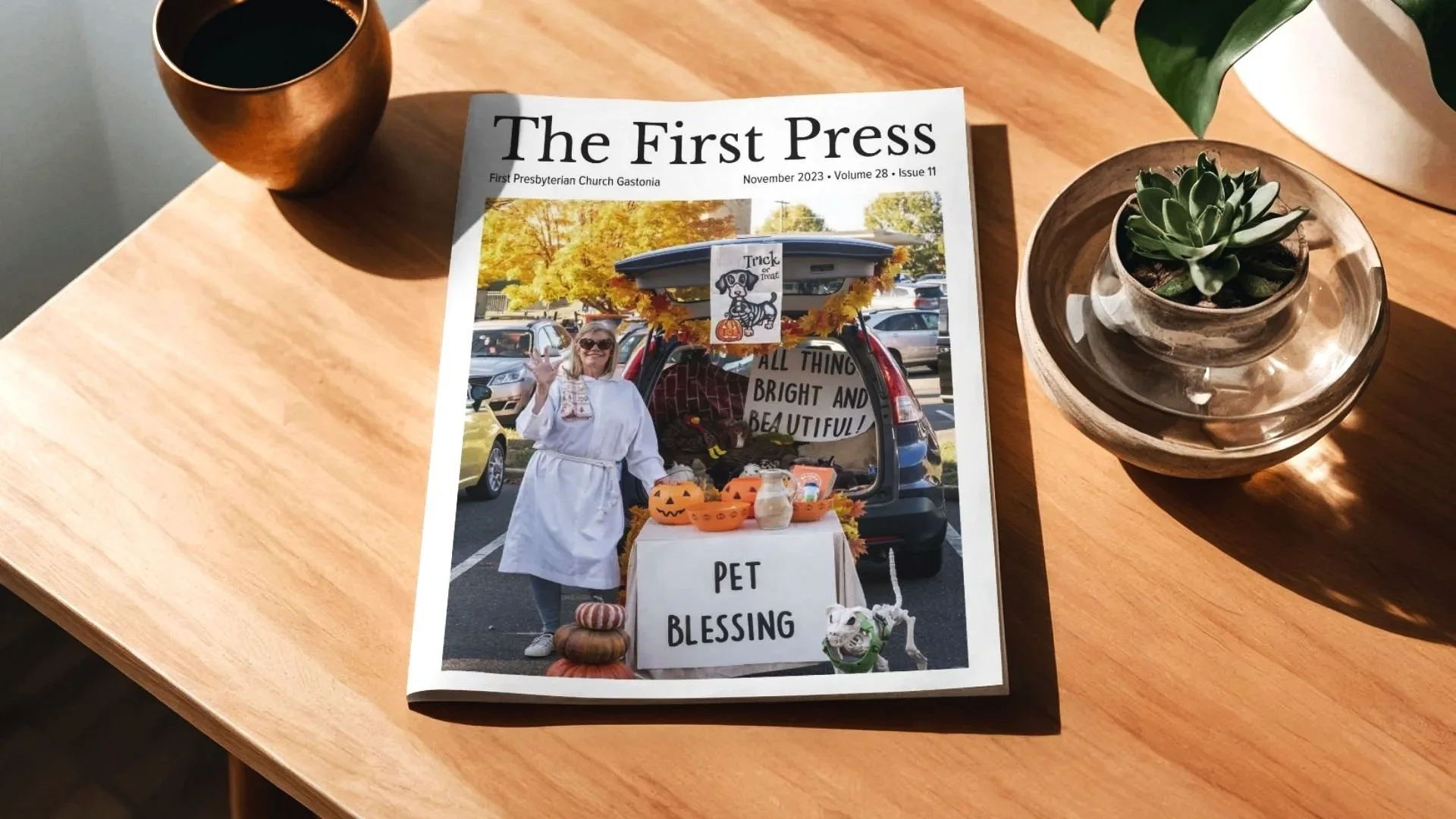 newsletter sitting on a wooden table between coffee and succulent