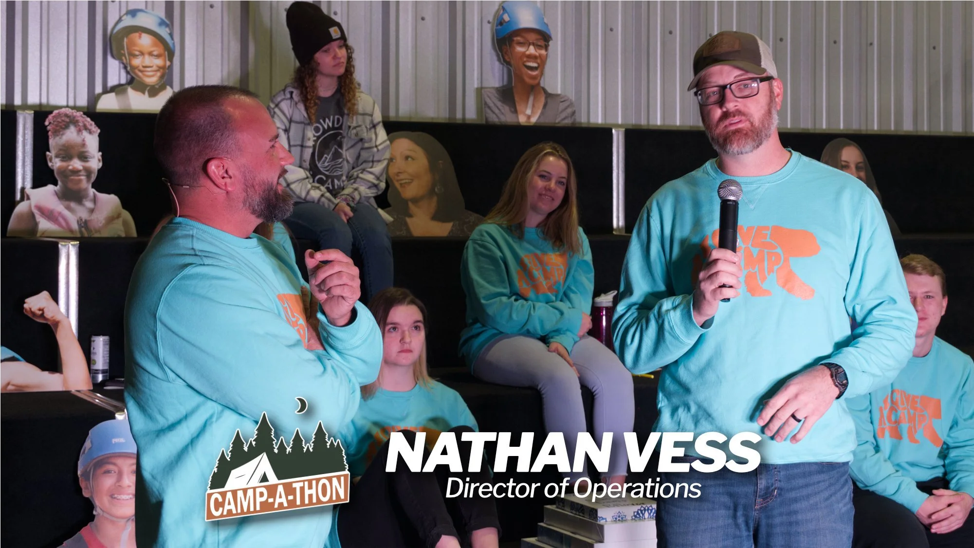 two men talking into microphones in front of a crowd