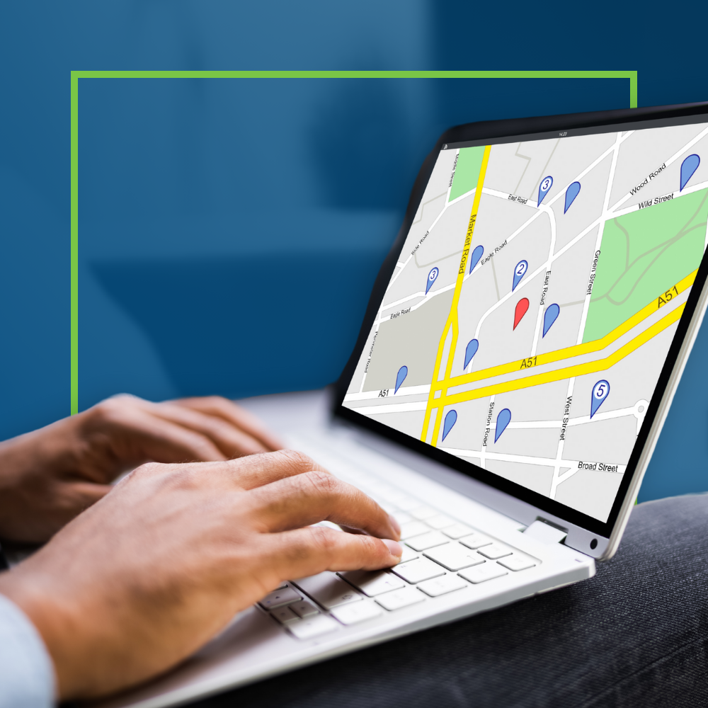 Hands on a laptop showing a map with location pins