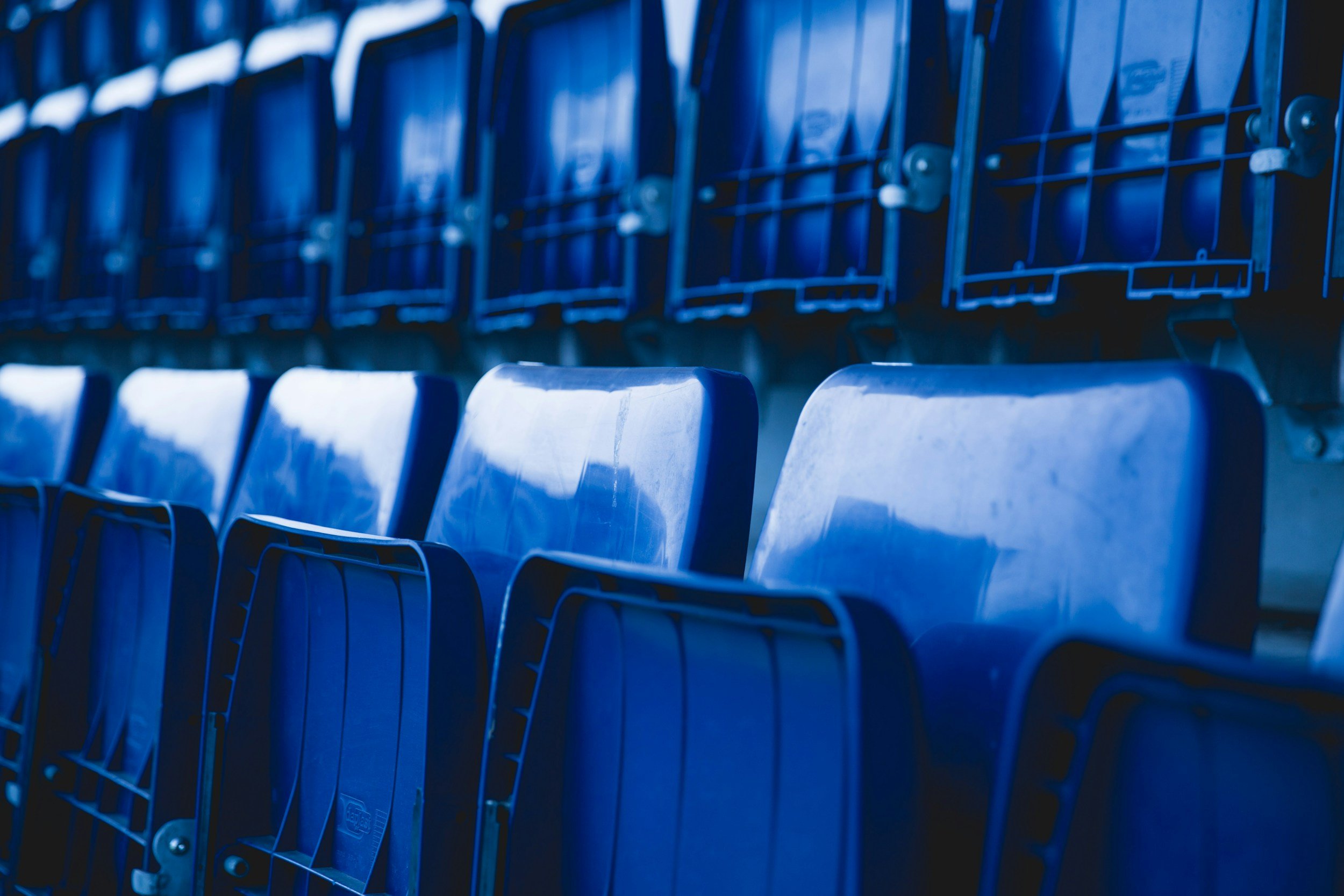 Blue stadium seats arranged in rows.