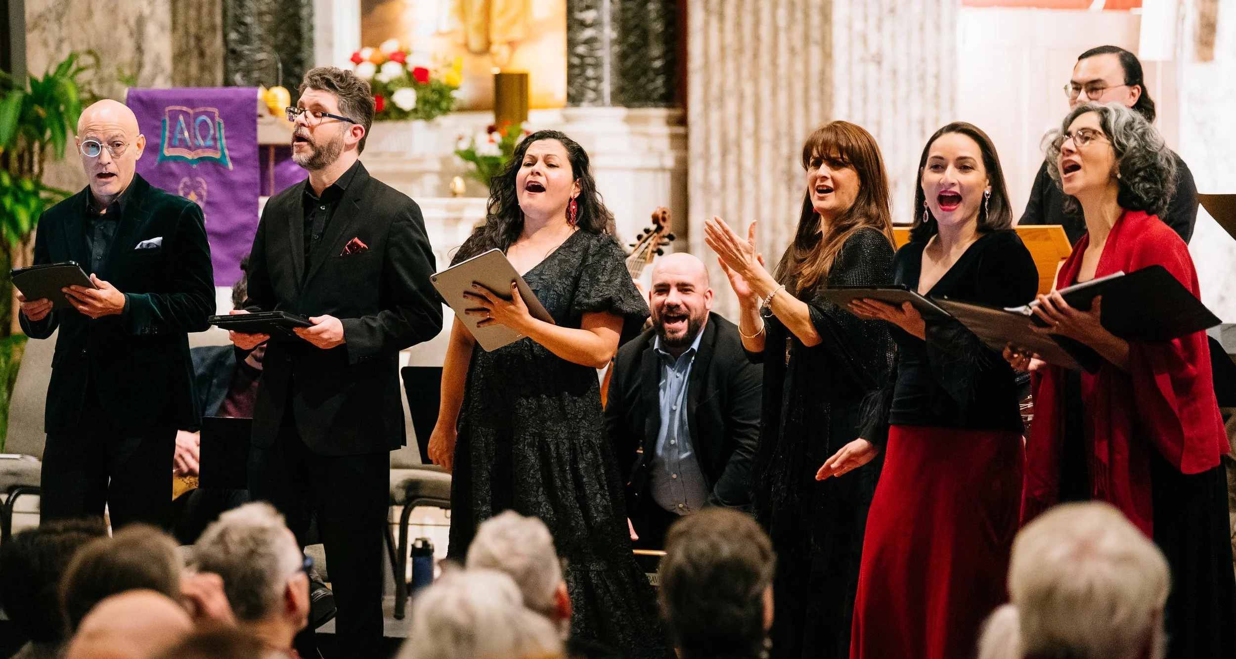 A festive group of musicians sings and plays music for a crowd.