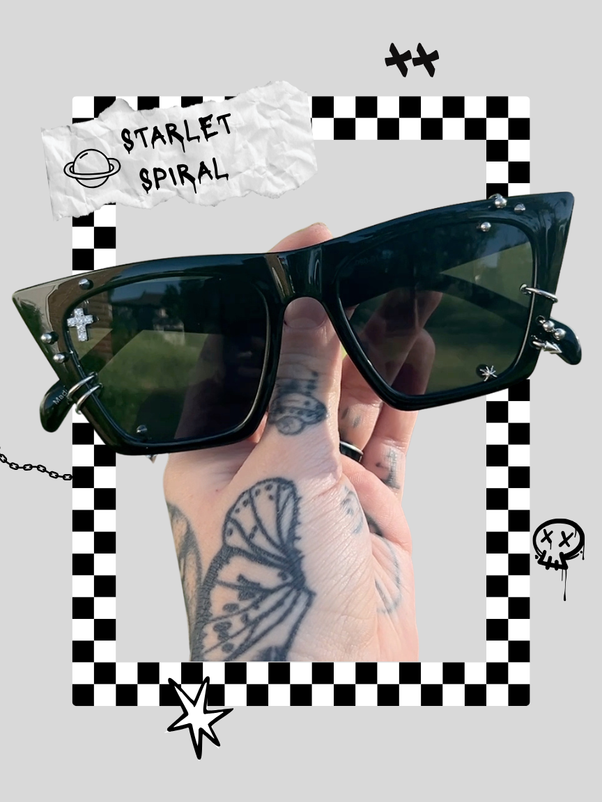 A person holding a pair of black sunglasses with tattoos on their hand, including a butterfly design. The background features a checkered pattern with doodles and text that reads 'Starlet Spiral' and a planet sketch.