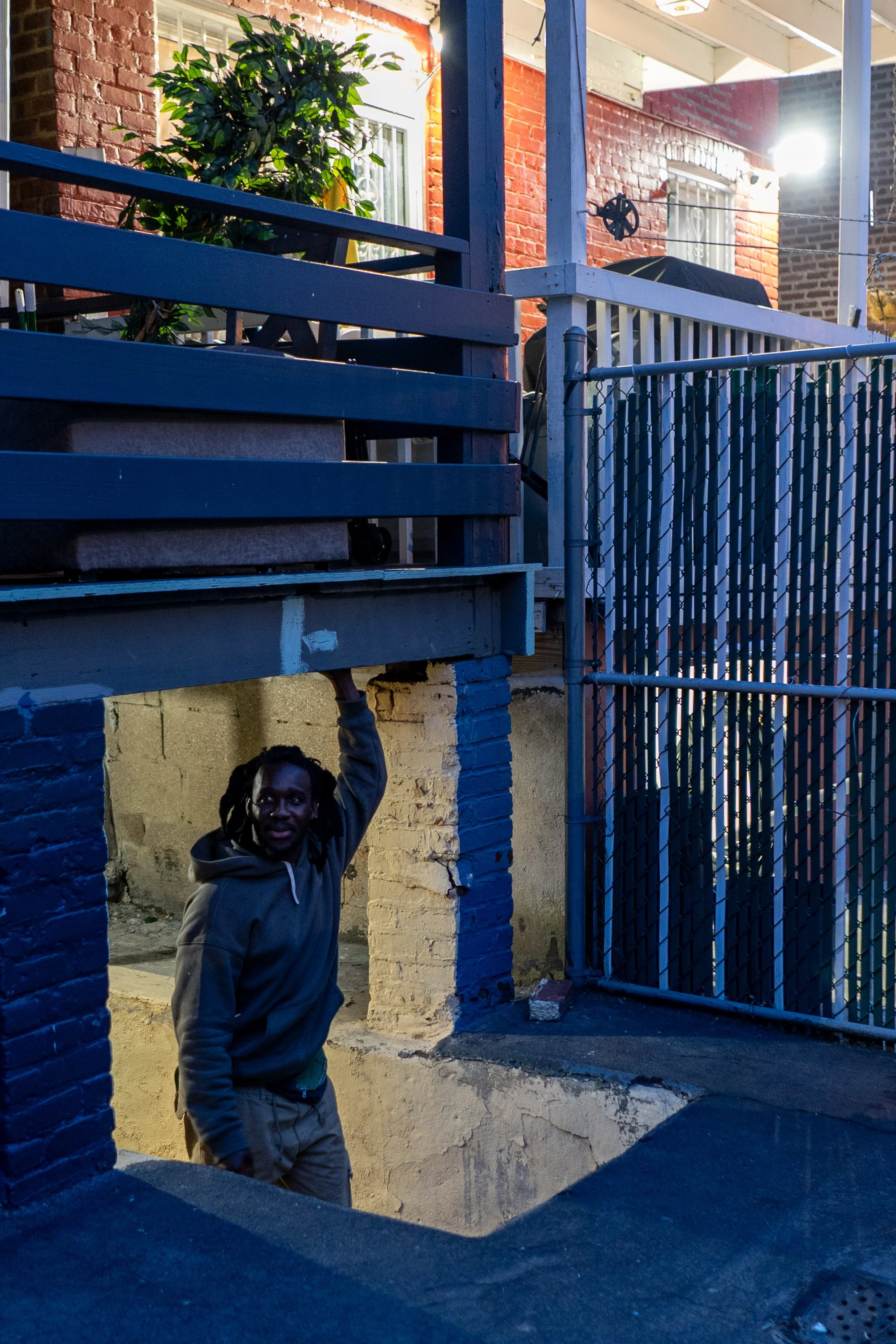 Bronx, March 2026 — Souleuye stands in his apartment in the Bronx. He now has his own room and works two jobs, delivering food and providing informal hair services.