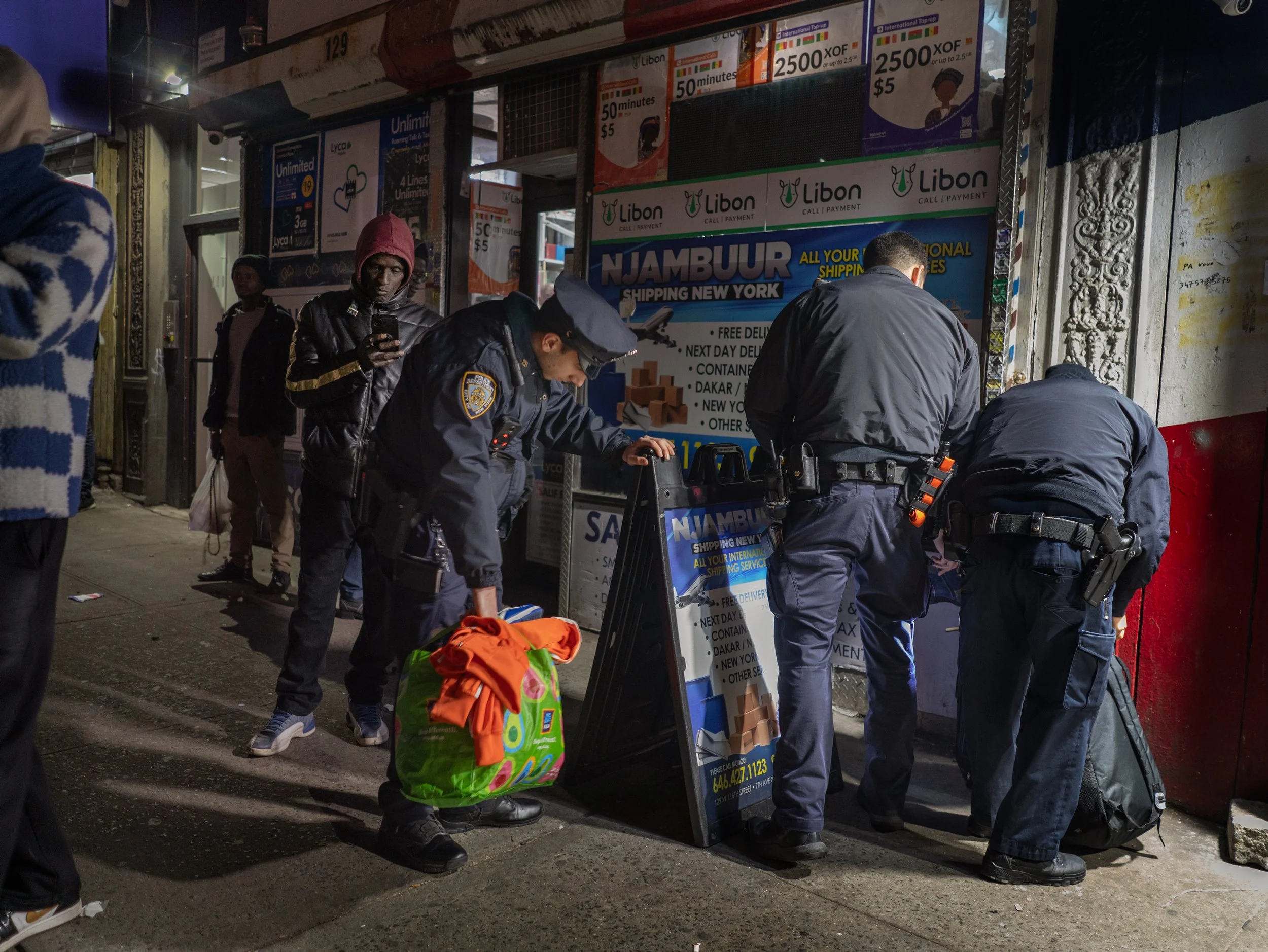 West 116th Street in Harlem, March 5, 2025 — New York Police Department officers confiscate shoes and clothing from Seck, a Senegalese immigrant, for unlicensed street vending.