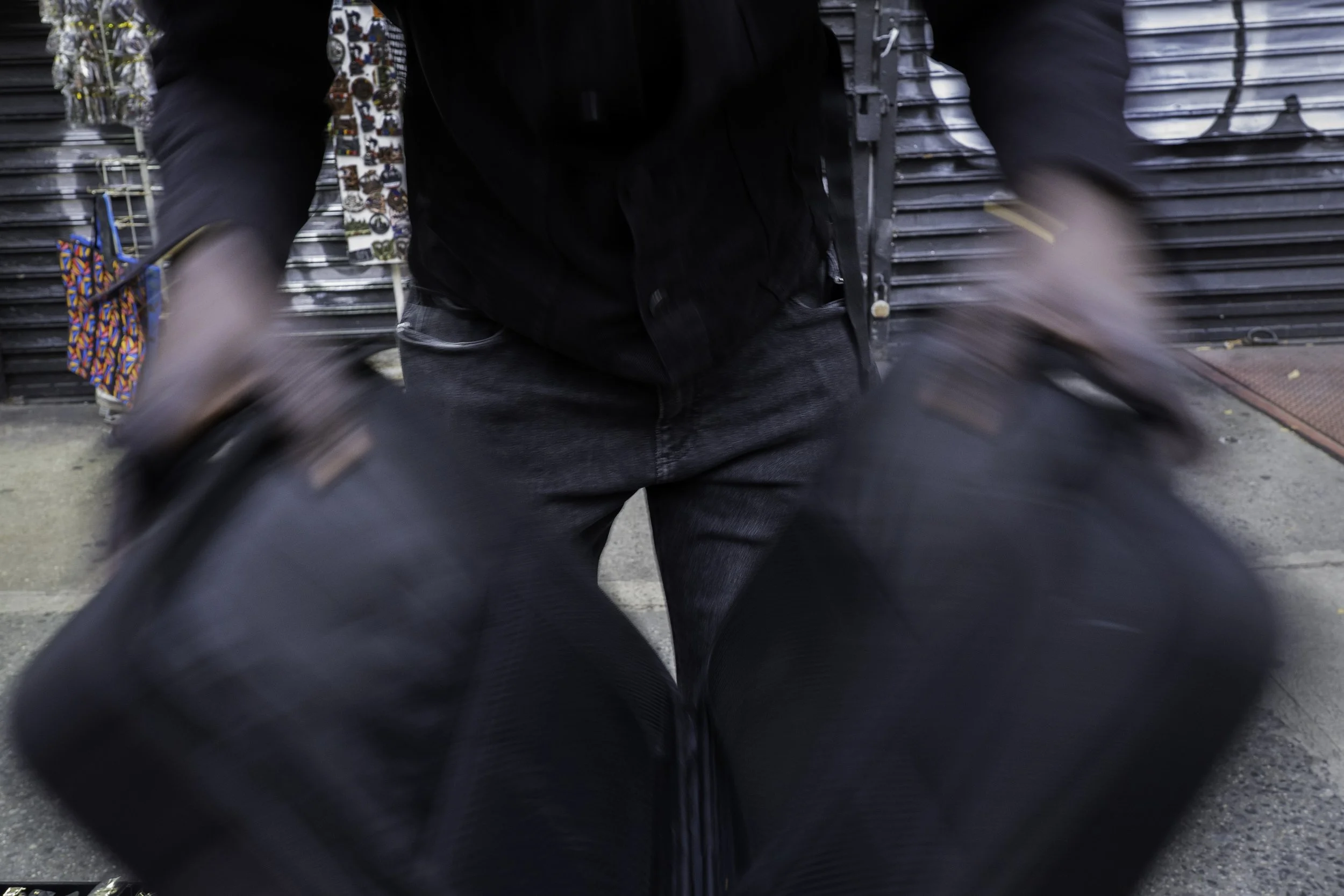 Canal street, NEW YORK, November 2025 — Noreyni (a pseudonym) packs up his goods after hearing a police siren and warnings from fellow vendors that officers were approaching.