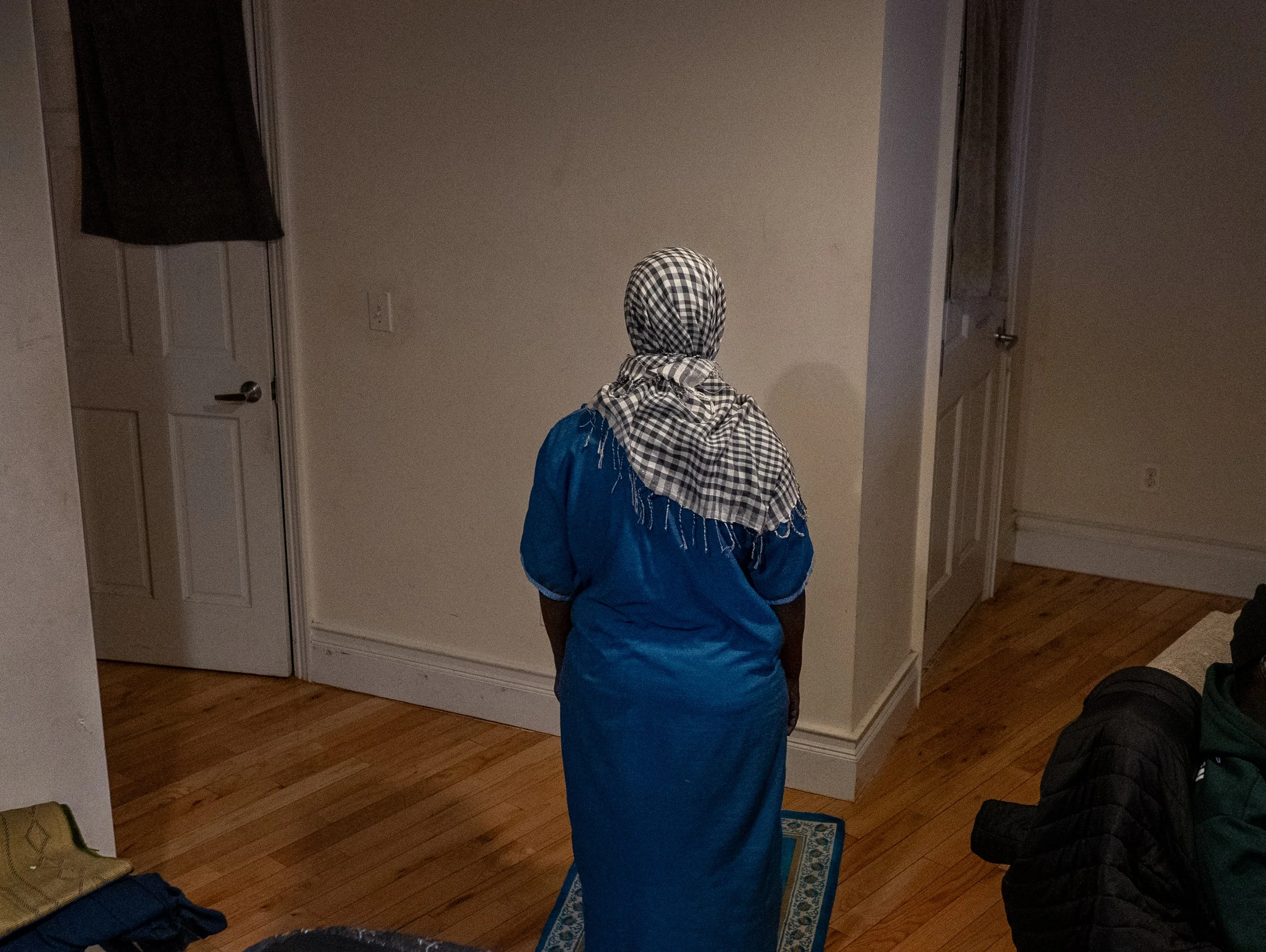Bronx, February 2026 — Betty prays while preparing tea at her apartment in the Bronx for sale the next day.
