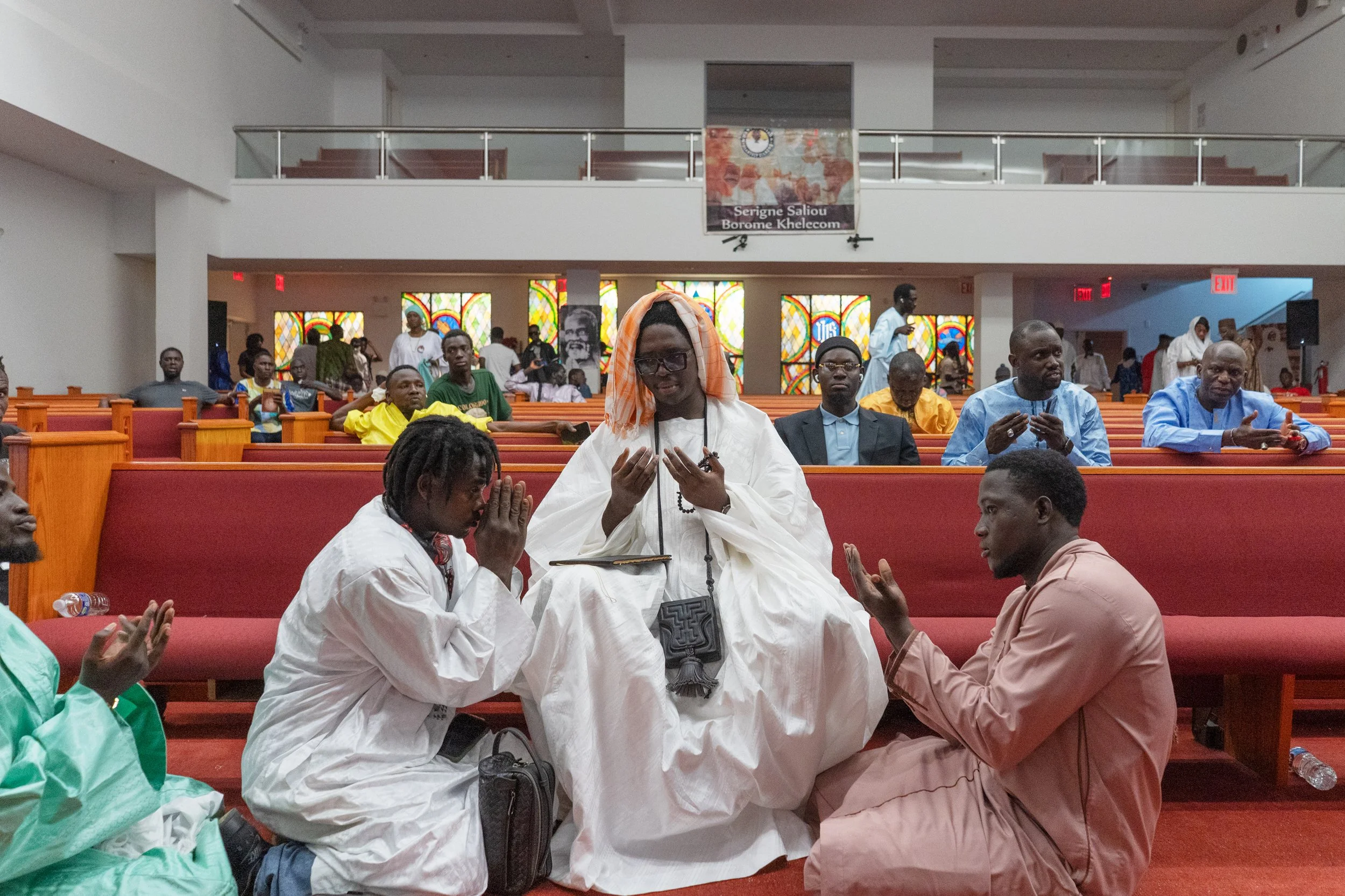 Bronx, New York — Asse Bamba and a fellow street vendor pray with Mame Thierno Mbacke Imam Borom Darou Sani, a Mouride religious leader visiting from Touba, Senegal in the Bronx on Sunday, July 6, 2025 at Williams Institutional CME.

 Touba is the ho