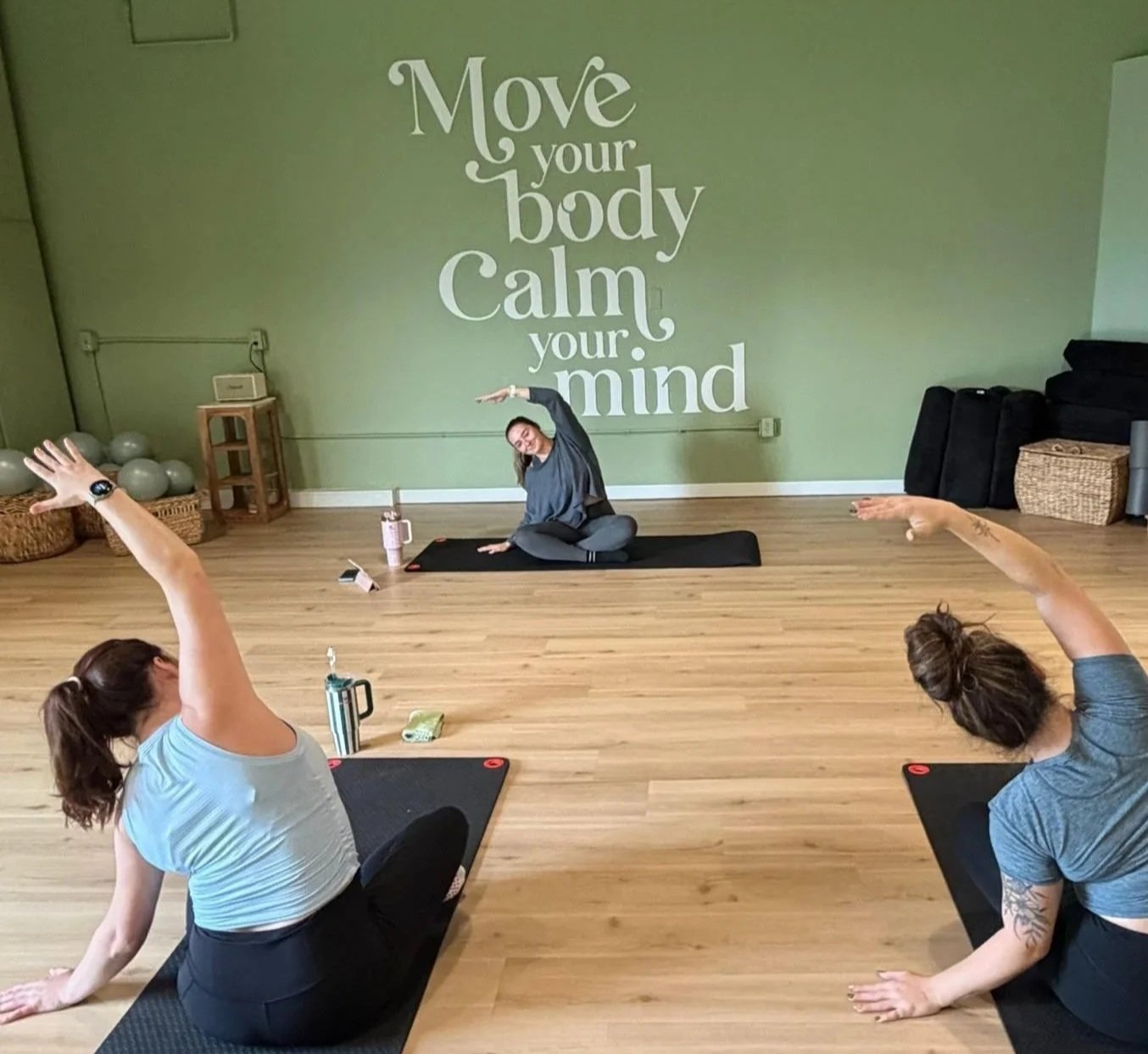 Older woman practicing seated meditation with a group in a Pilates studio
