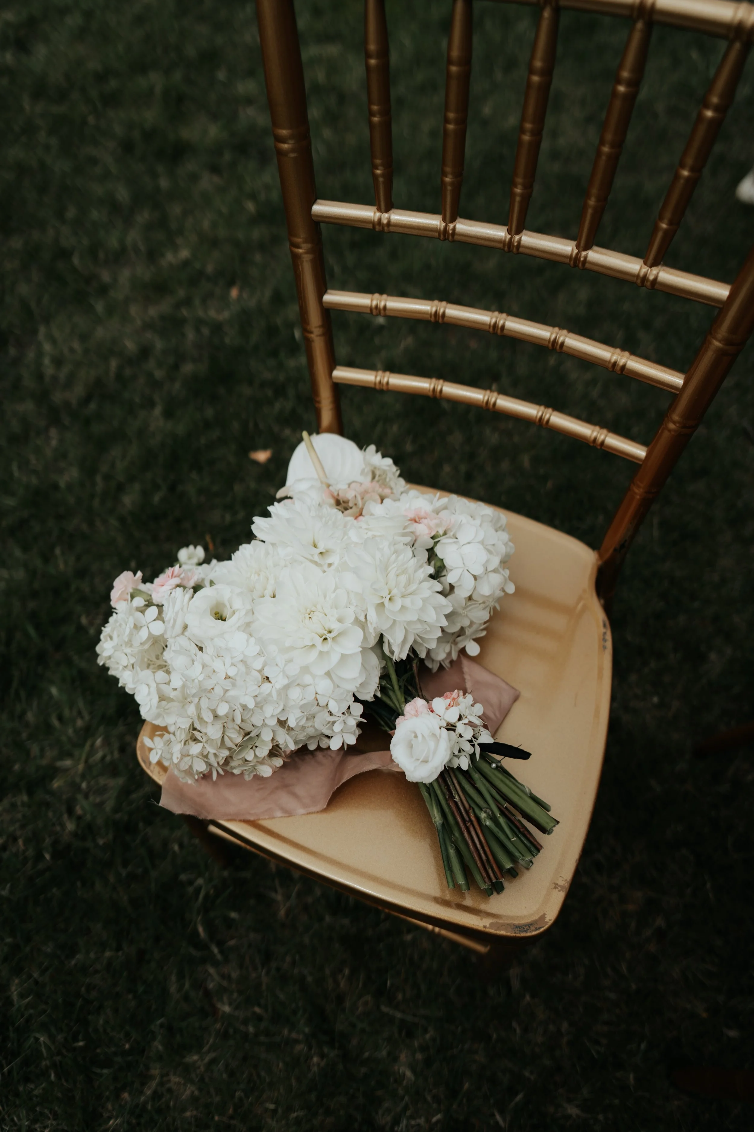White floral bouquet on a gold chair, outdoor setting