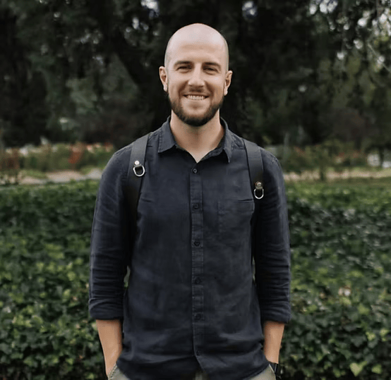 Bald man in black shirt with a backpack outdoors