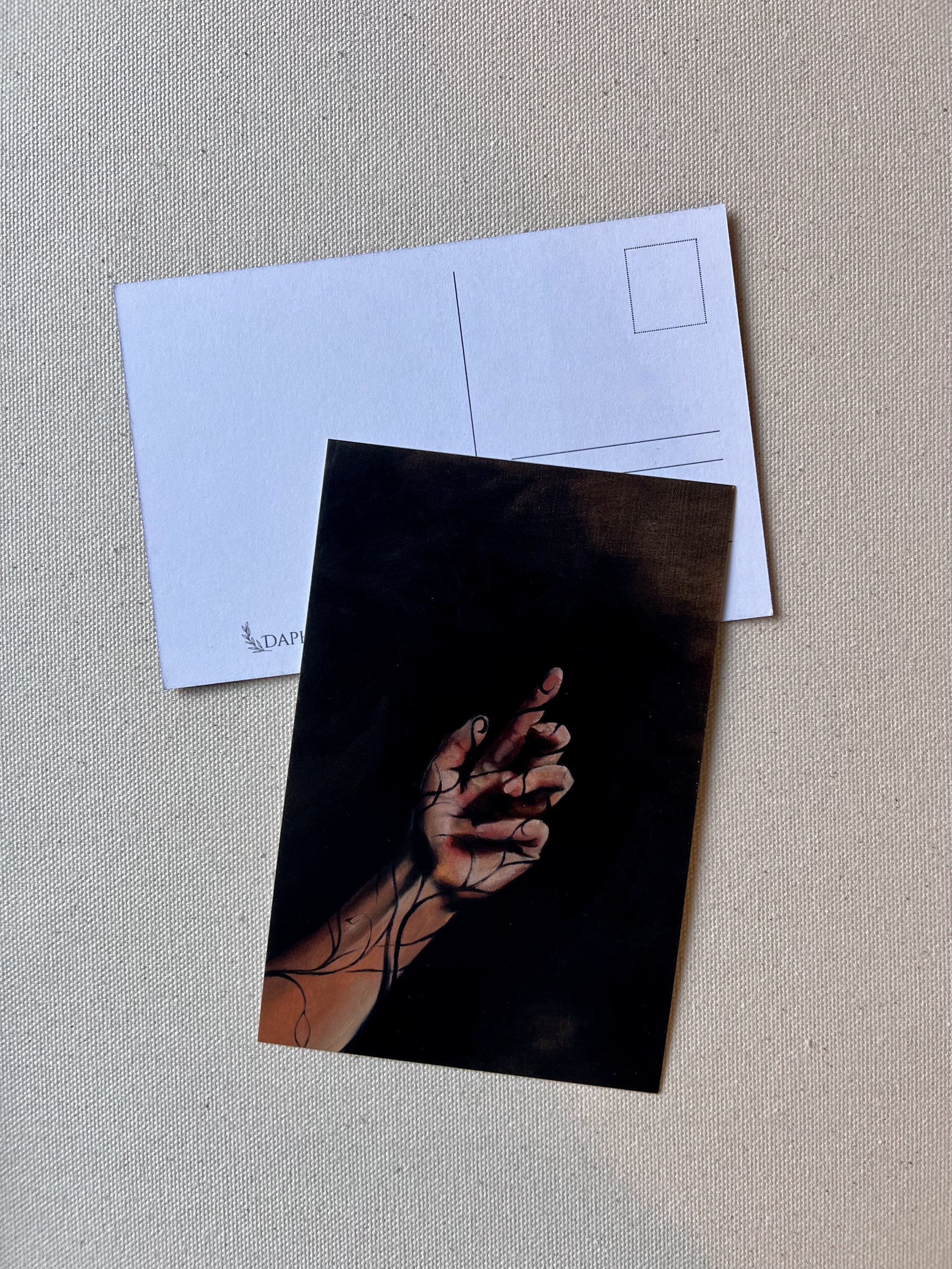 Front and back view of a postcard. Front features an image of an oil painting featuring a hand.