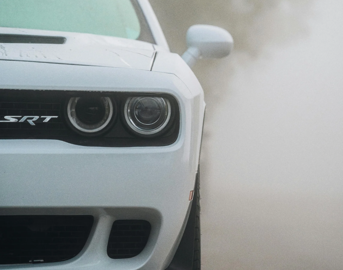 Front view of a white Dodge Challenger SRT with foggy background.
