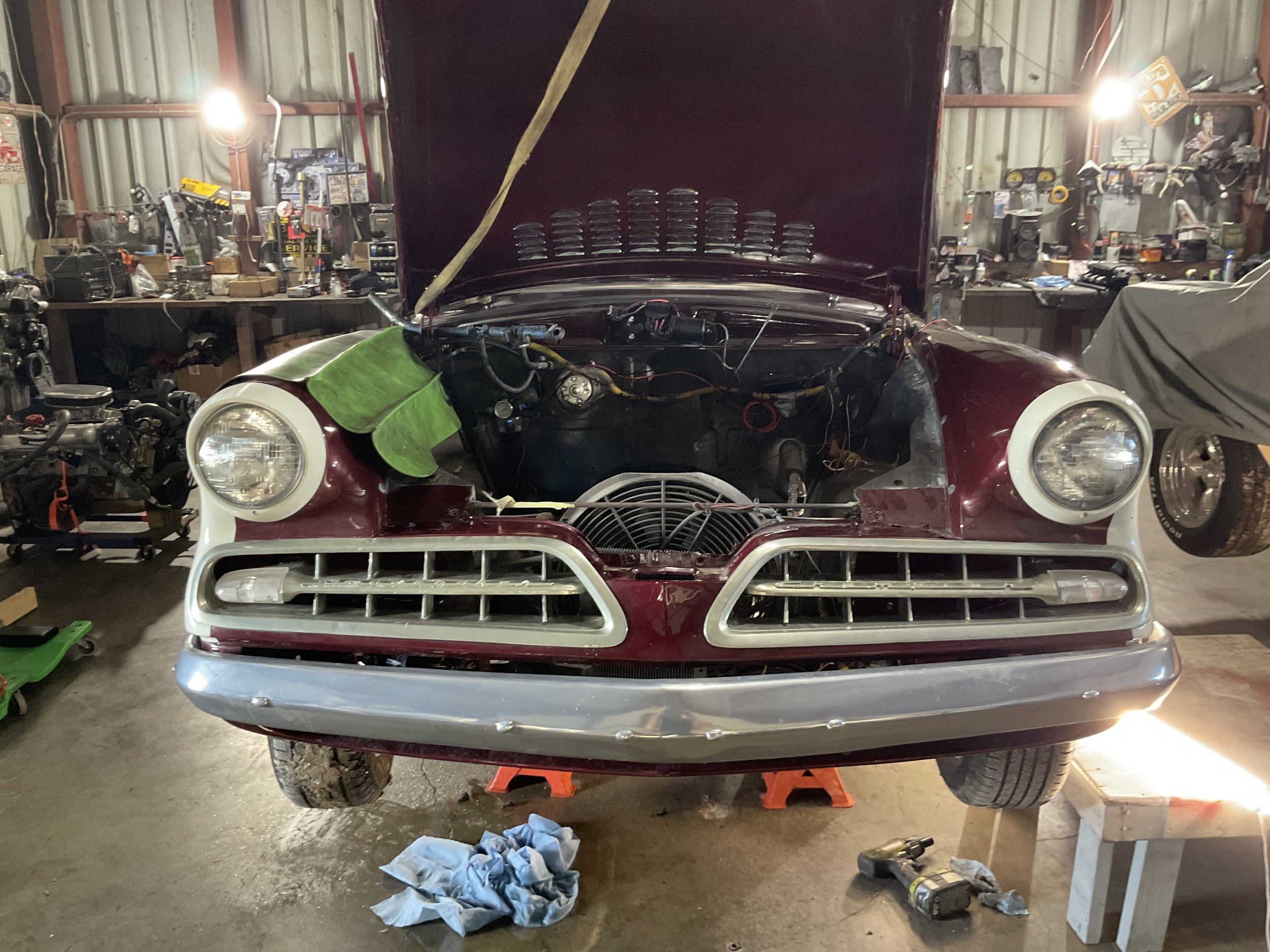 Vintage car with hood open in a garage workshop