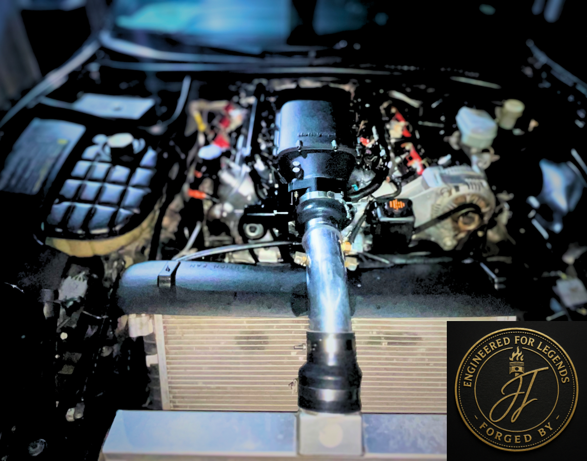 Car engine with a performance air intake system, visible components, and a logo that reads 'Engineered for Legends, Forged by...'. Close-up view in a workshop setting.