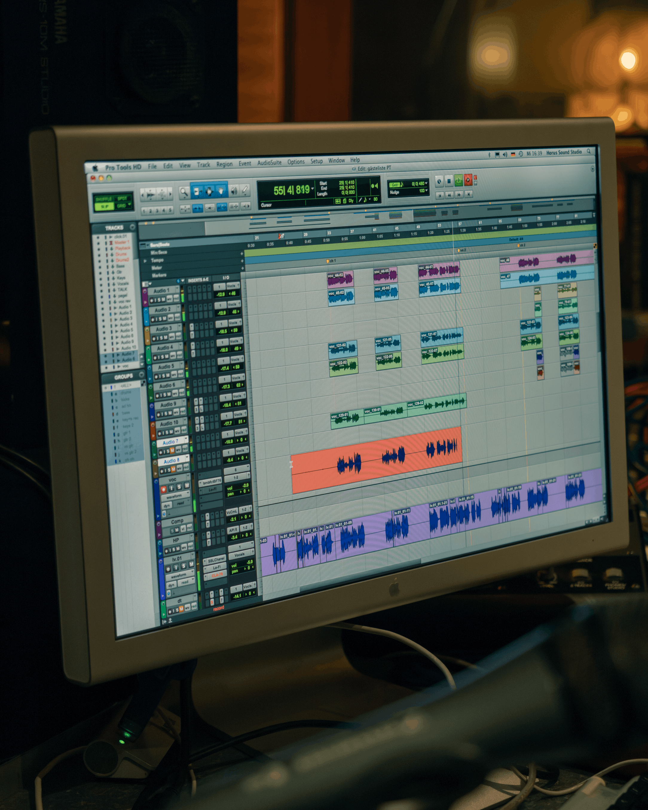 Computermonitor mit einer digitalen Audiobearbeitungssoftware, die verschiedene Tonspuren, Wellenformen und Steuerungsfenster zeigt.
