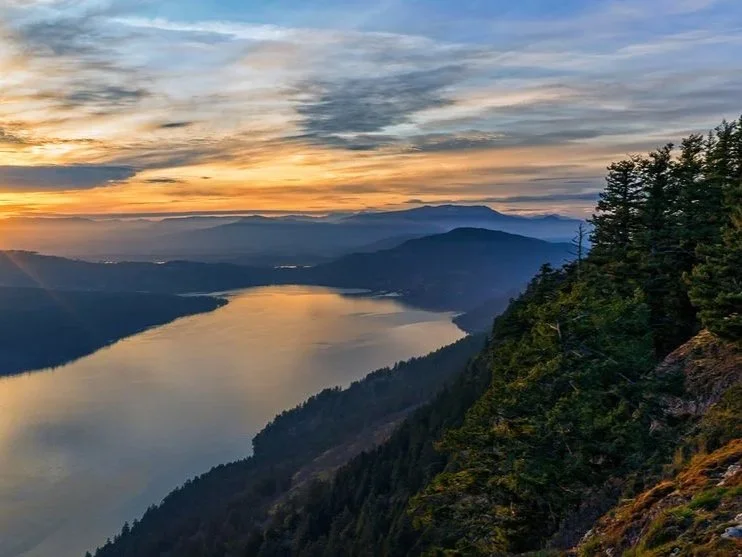 Sunset over a river canyon with trees on a hillside