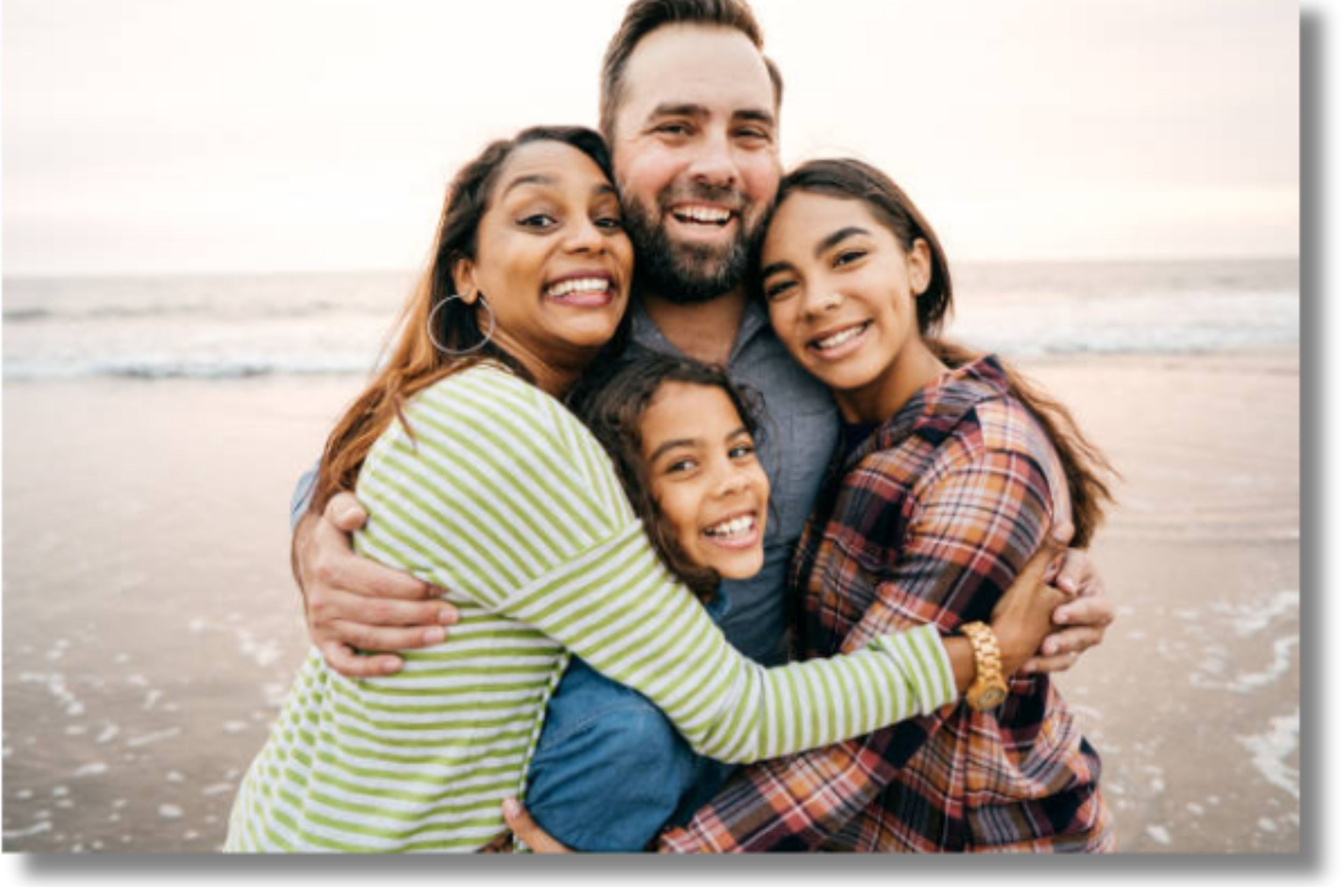 Family embracing on the beach, representing parent coaching and supportive family relationships