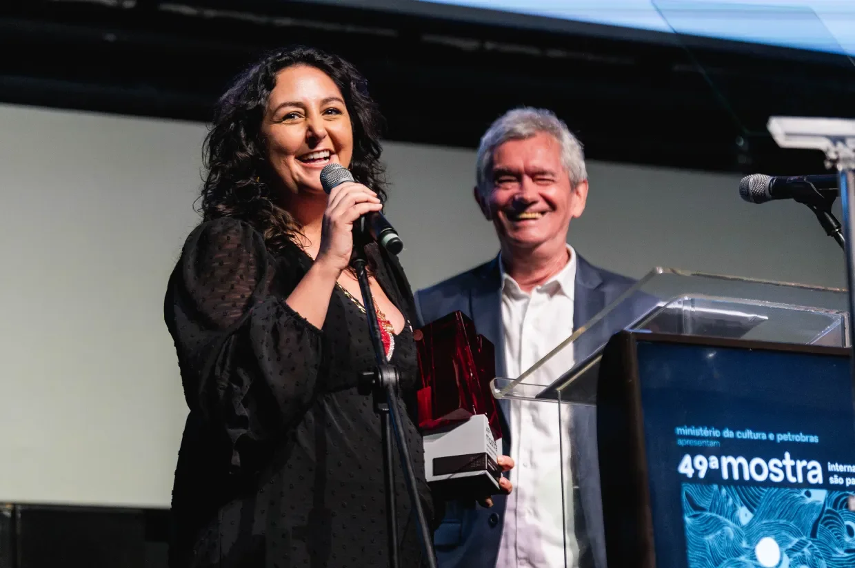 Cintia recebe o Prêmio Netflix ao lado do apresentador da cerimônia Serginho Groisman. Crédito: Helena Yoshioka/Netflix