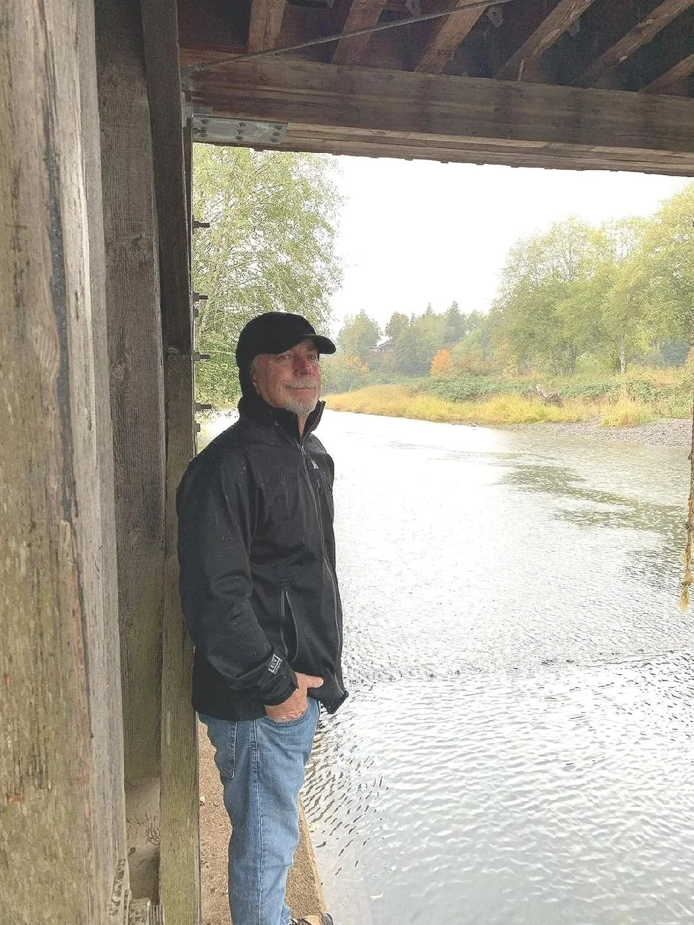Author and ShopHenCo Books founder Mark Henning standing beside a river