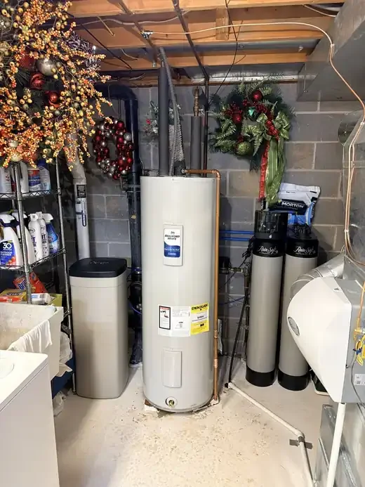 New Bradford White electric water heater installed with insulated lines and relief valve discharge pipe