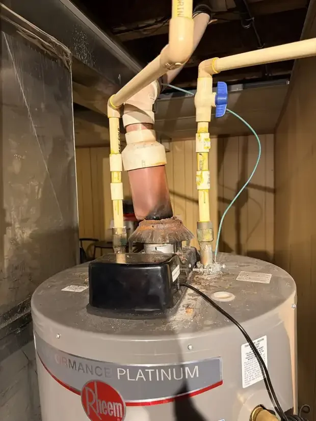 Rheem gas water heater with plastic pipe used as the exhaust vent, scorched and melting at the draft hood