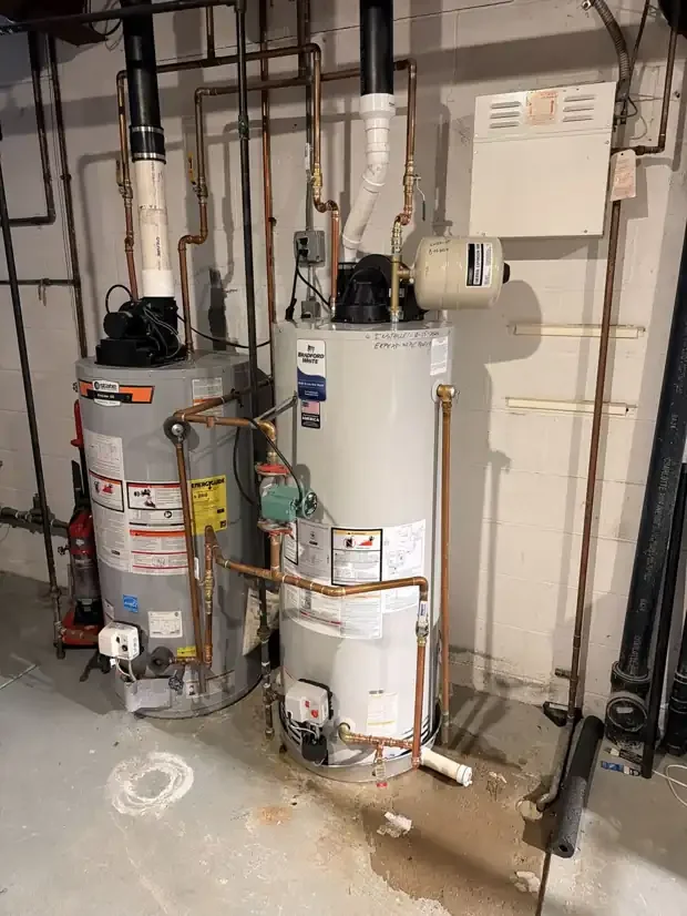 New Bradford White power-vent gas water heater installed beside an existing commercial tank with a recirculation pump and thermal expansion tank