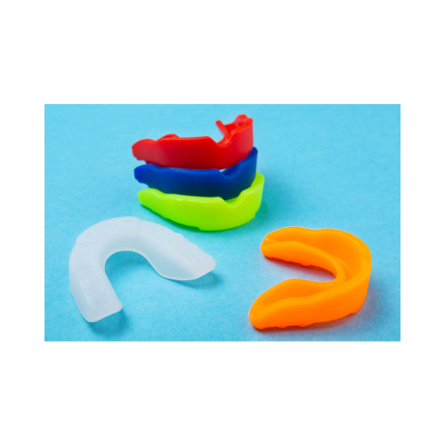 Colorful dental night guards arranged on a blue background.