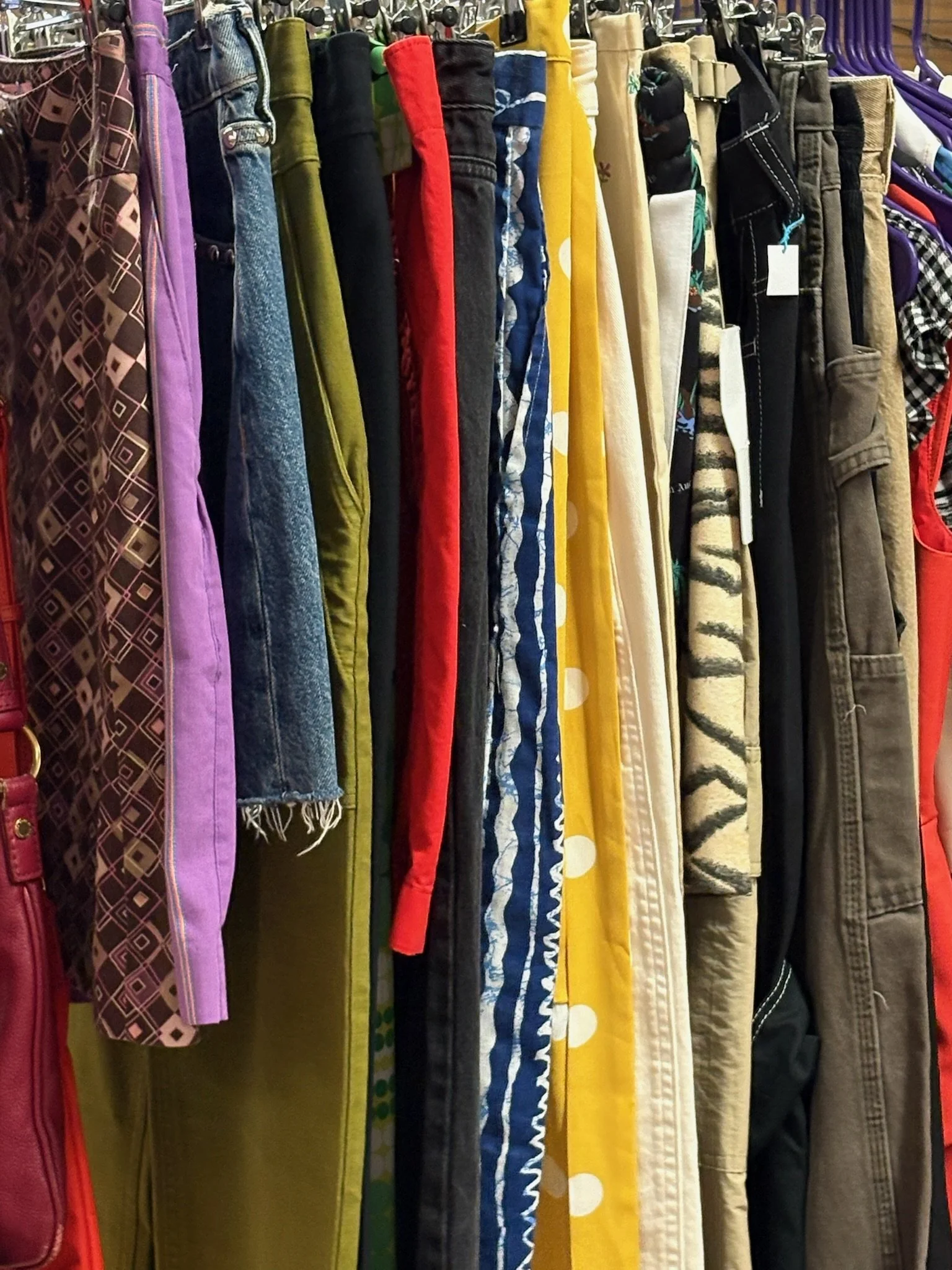 A rack with colorful skirts and pants.