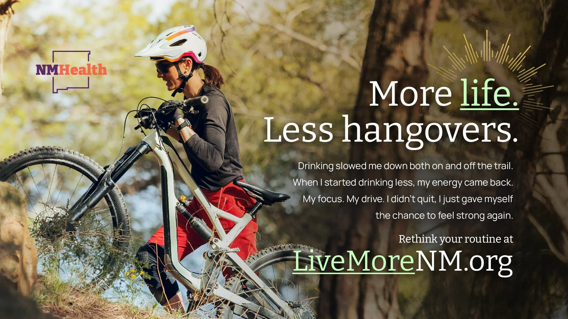 A woman in a helmet and sunglasses riding a mountain bike on a trail in a forest during daytime, with sunlight filtering through the trees, accompanied by the LiveMoreNM.org logo and text promoting healthier living.