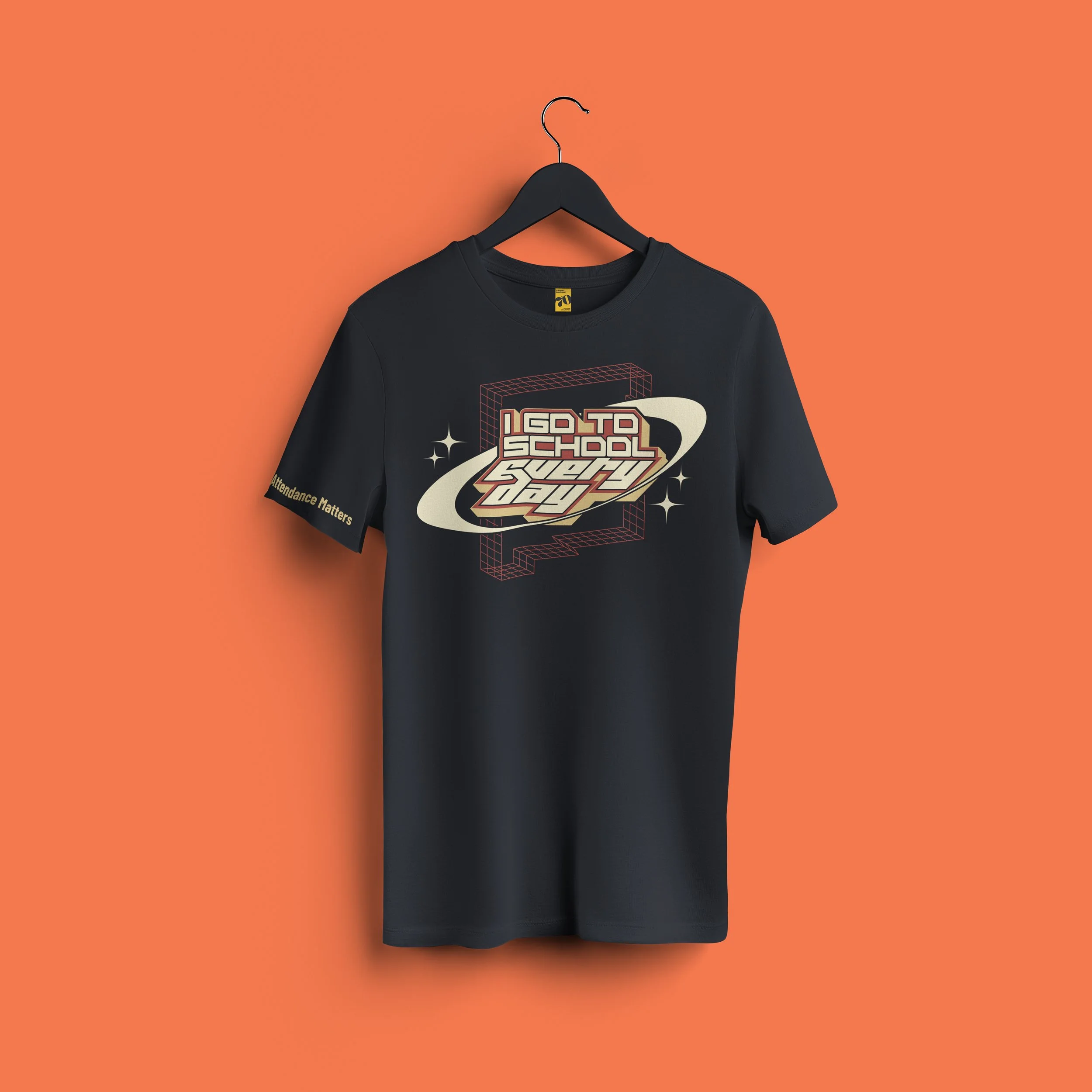 Black T-shirt on a black hanger against an orange background, with a retro-futuristic graphic design and text reading 'I GO TO SCHOOL'