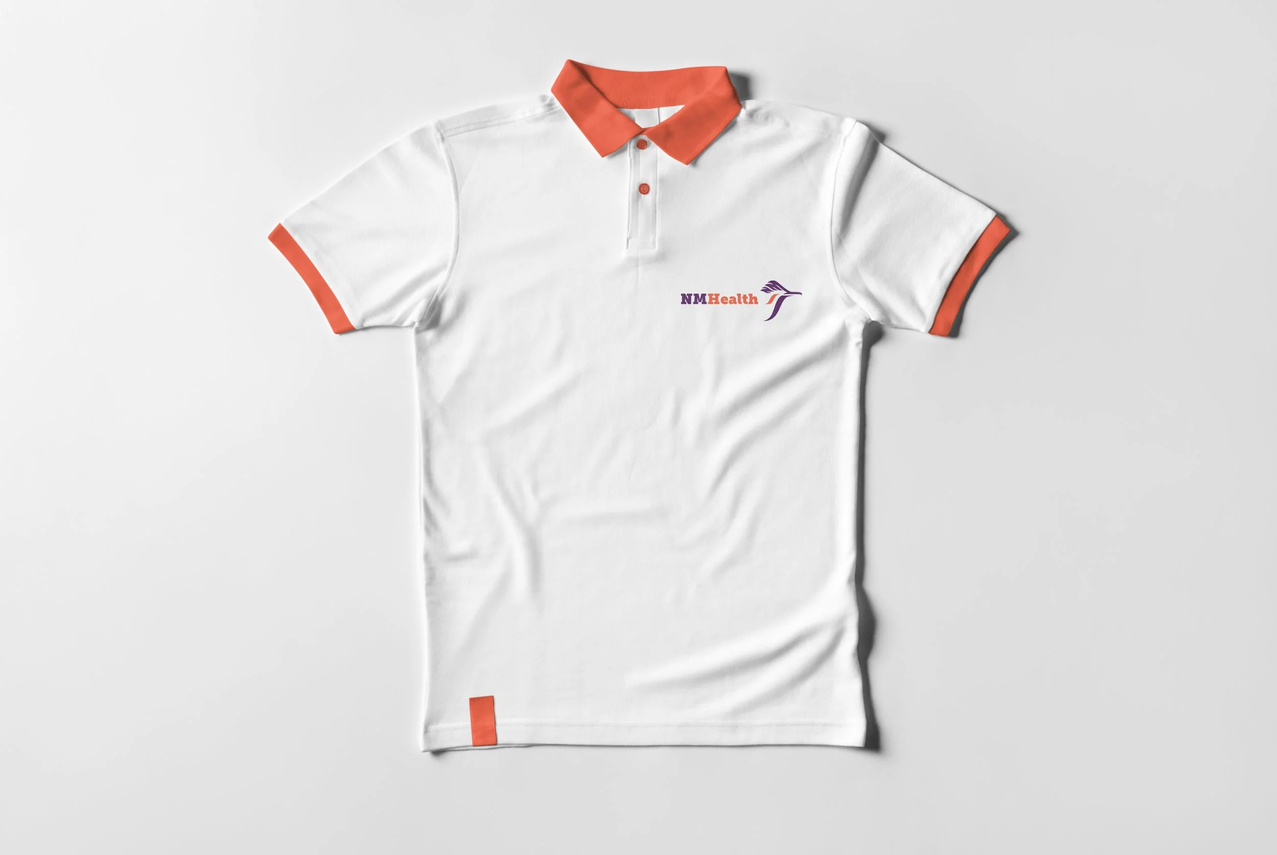 White polo shirt with orange collar and sleeve cuffs, and logo reading 'NMHealth' with a stylized purple hummingbird on the chest.