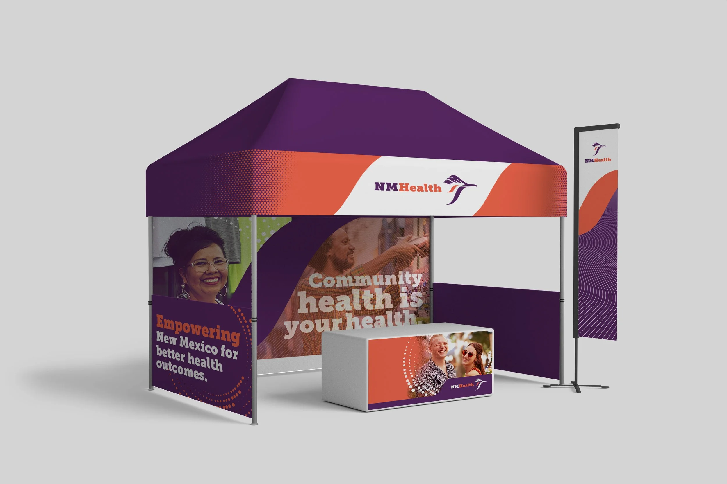 A promotional booth with purple, orange, and white branding for NM Health, featuring images of smiling people and messages about community health and empowerment.