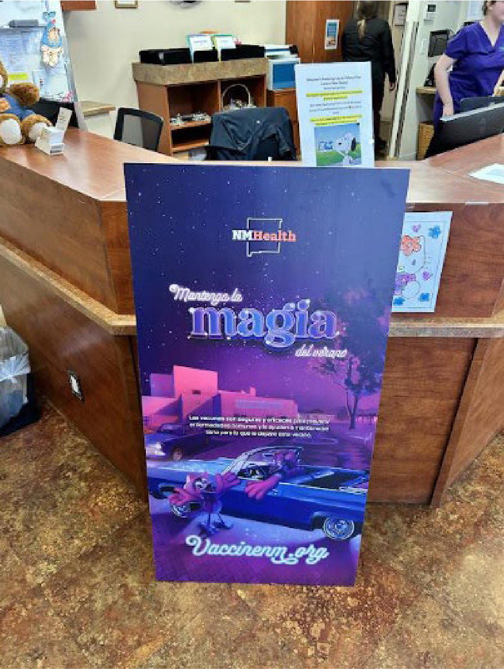 A promotional stand or sign for a movie titled 'Managua magía de un sueño' with a graphic of a retro car and cartoon characters, in a reception or lobby area.