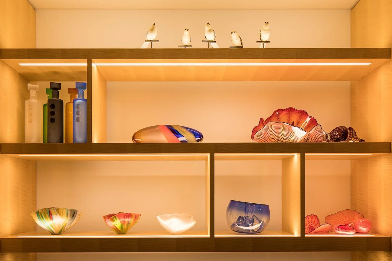 Shelving wall in Central Park South penthouse, Billionaire’s Row, New York, featuring lighting design by Tirschwell Lighting.