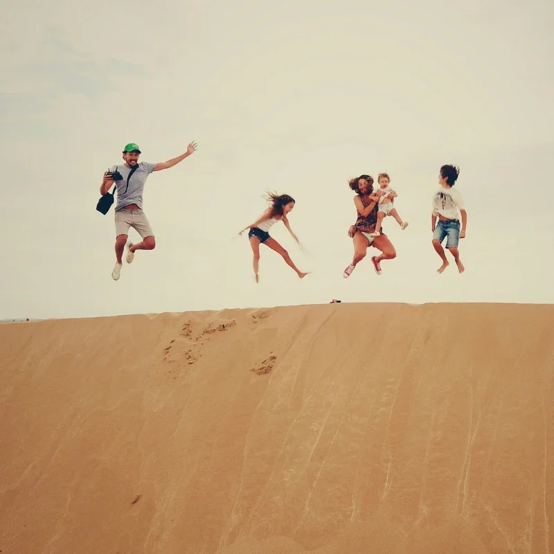 A photo of a family jumping in the air for a photo.