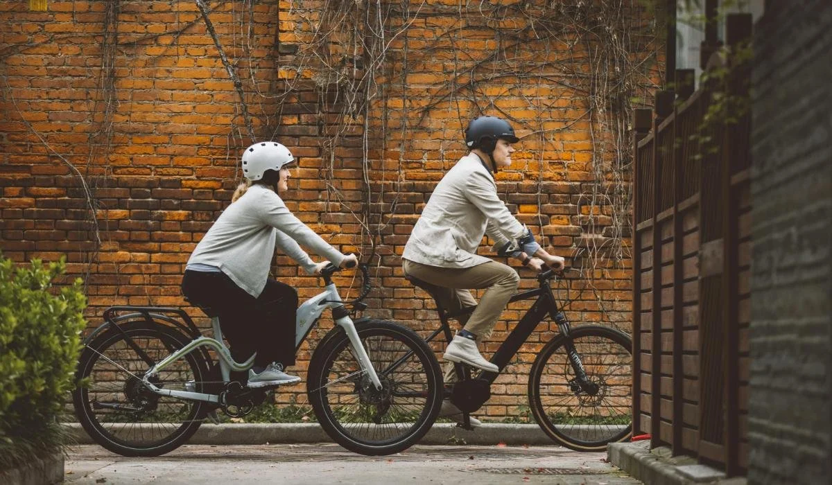 couple cycling an an old neighbourhood with brick walls