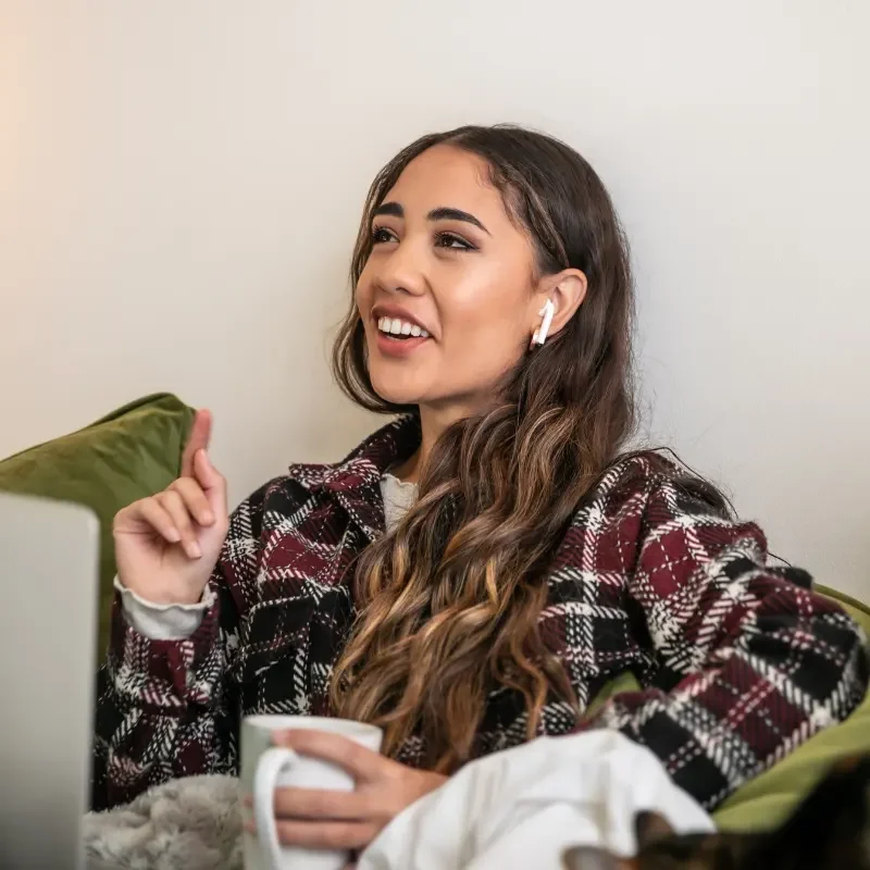 a young woman drinking coffee while talking to someone